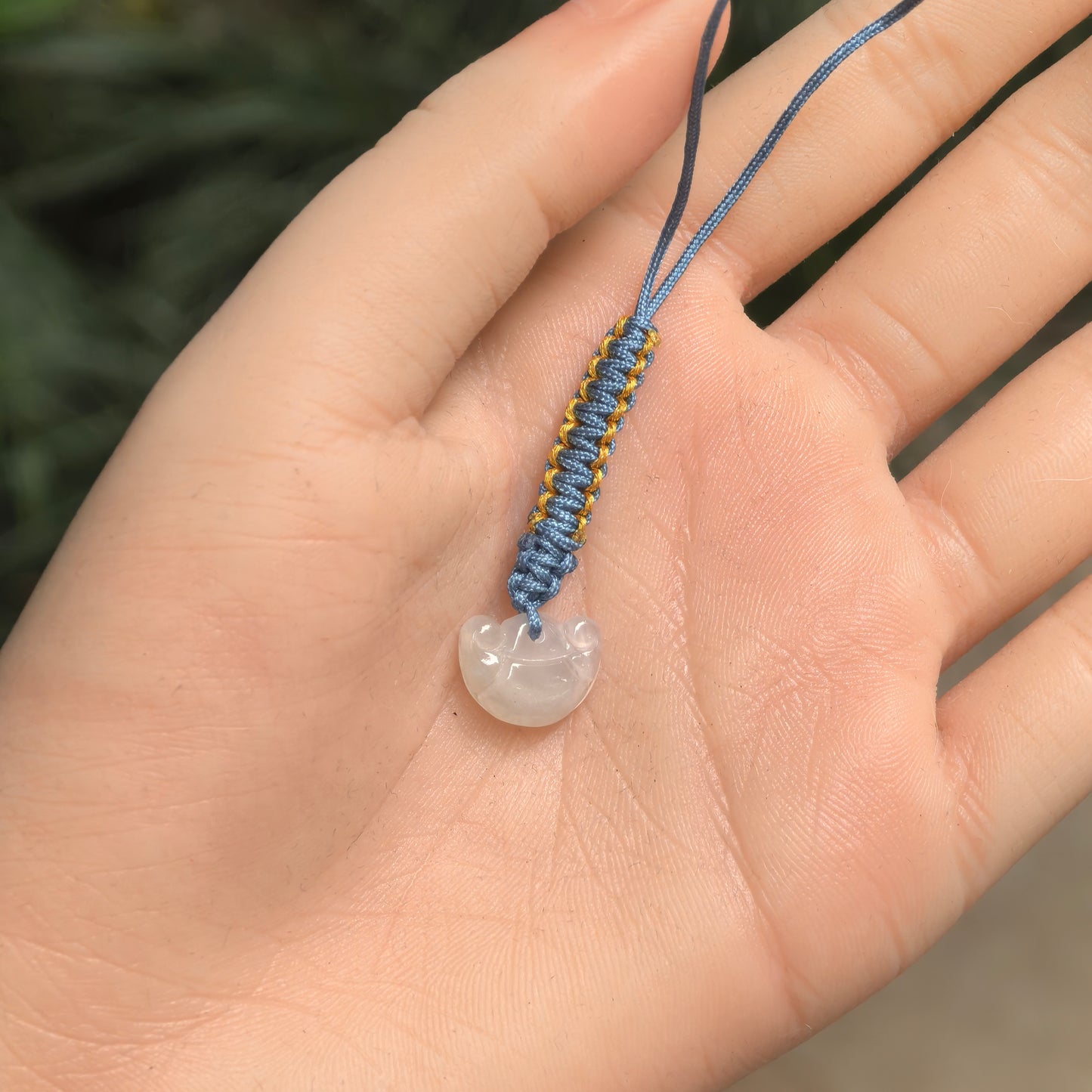 Petite white jadeite ingot bag charm shown in hand for scale with soft natural translucency.
