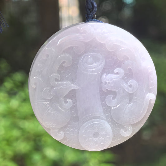 Natural Grade-A glutinous white carved jadeite feng shui ornament hanging on dark cord.
