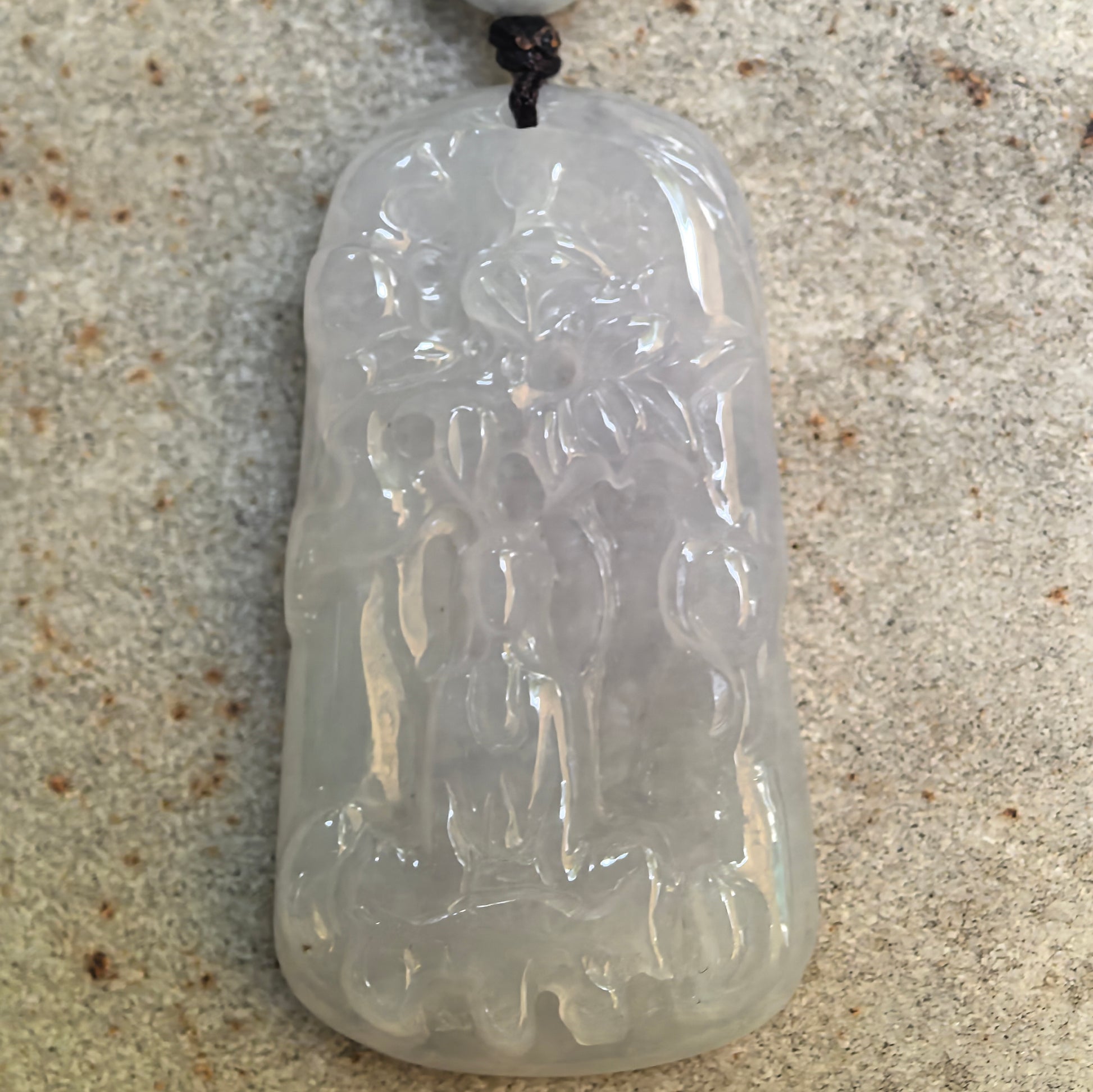 Front detail view of the abstract Guanyin jadeite pendant with flowing lines and natural internal cloudiness.
