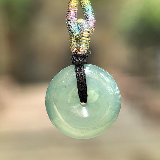 Natural Grade-A icy-glutinous deep green jadeite Peace Pendant hanging from a black cord.