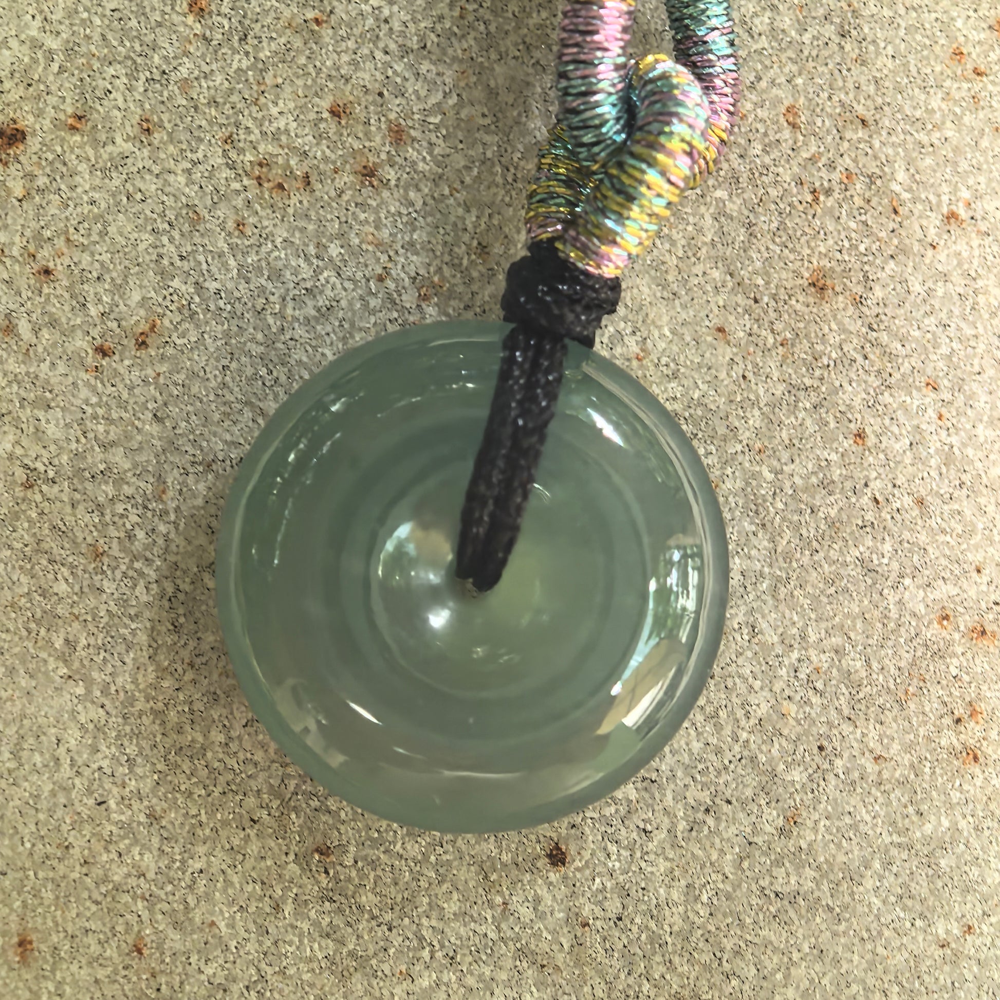 Detailed top view of an icy-glutinous jadeite Peace Pendant showing its polished surface and centered opening.