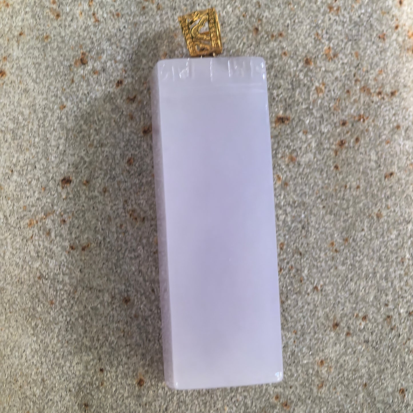 Front view of the minimalist lavender jadeite pendant with subtle decorative carving and an openwork 18K gold bail.