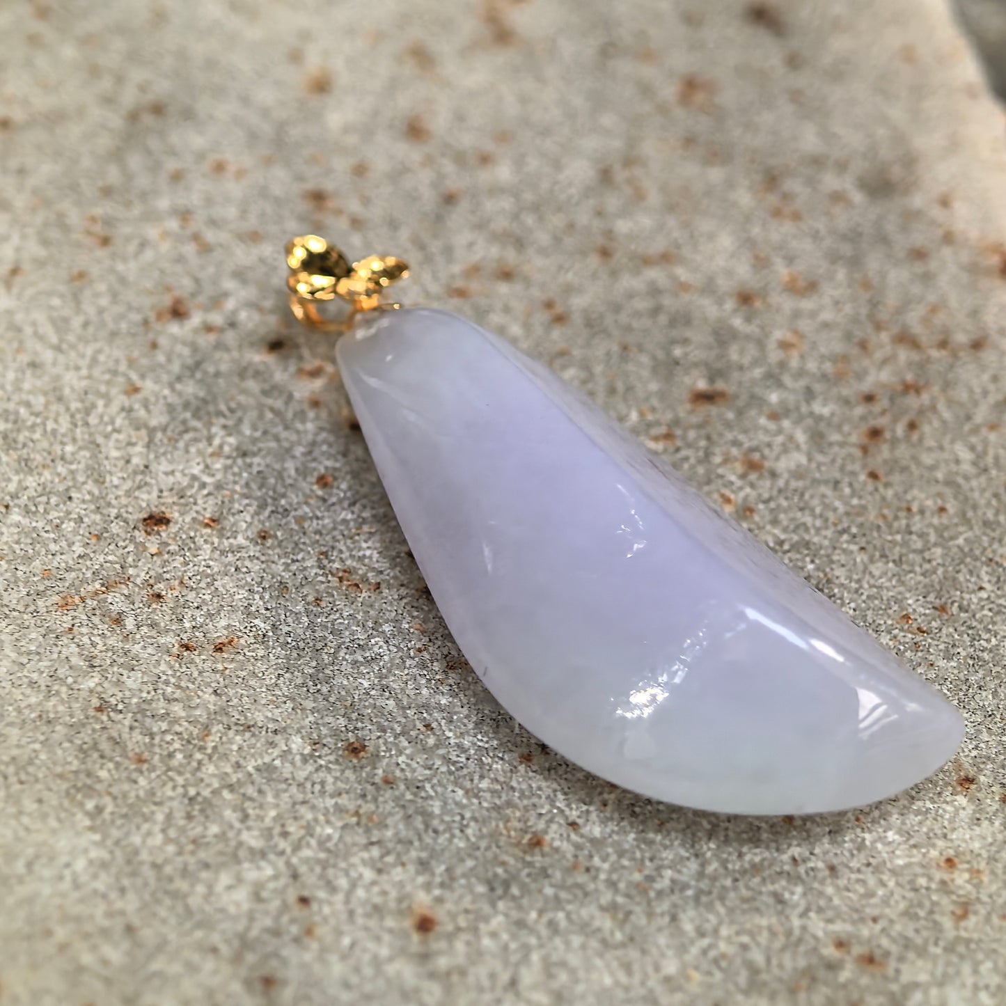 Side-angle close-up of the icy-glutinous lavender jadeite pendant showing its substantial thickness and rounded profile.