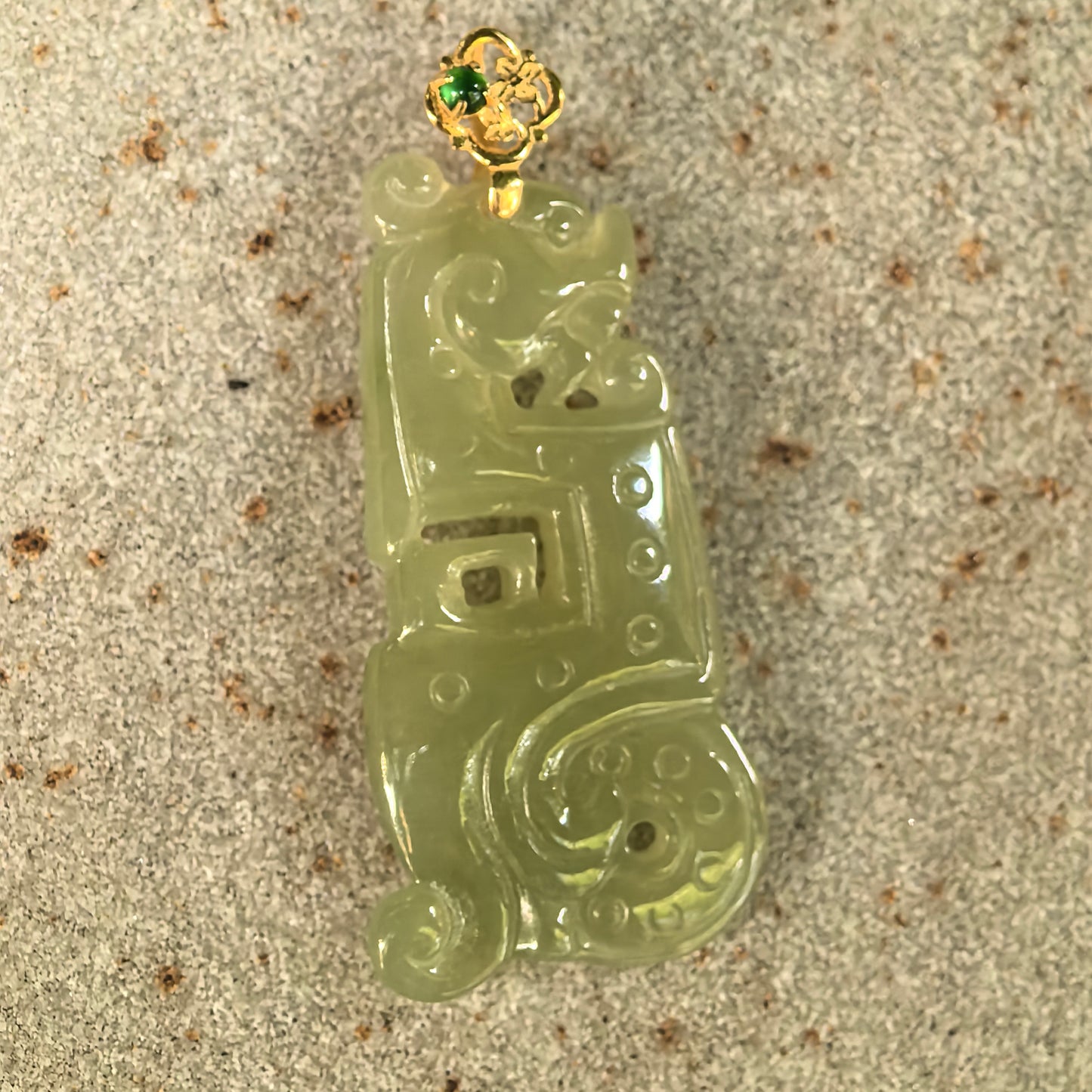 NGTC-certified yellow-green jadeite Kui dragon pendant displayed with its matching certificate and 18K gold fitting.
