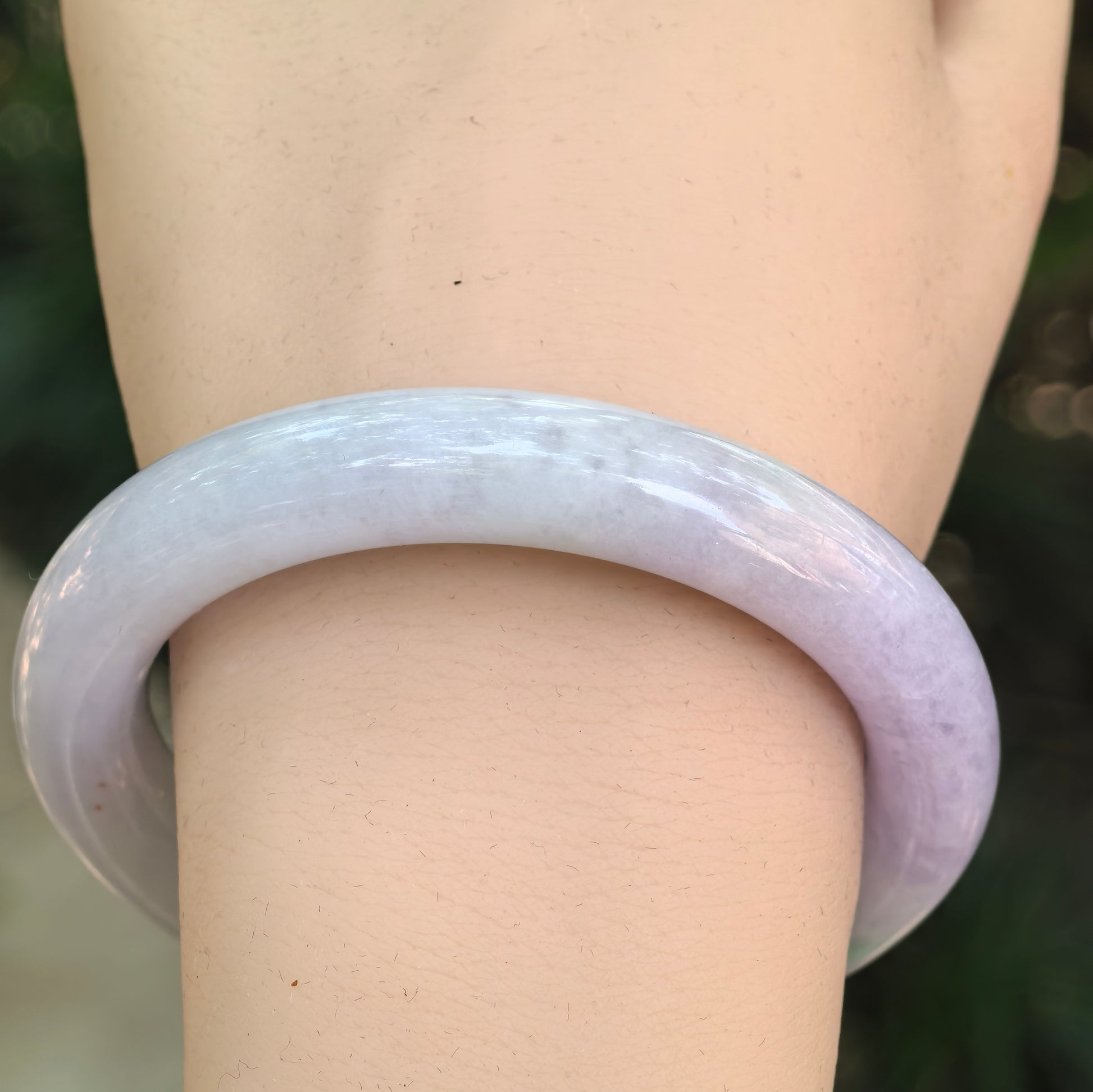 Close-up of a light lavender Burmese jadeite bangle showing its smooth luster and glutinous texture.