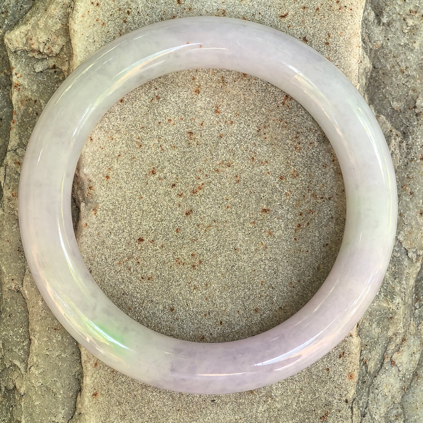 Top view of the glutinous light lavender and green Burmese jadeite round-bar bangle.