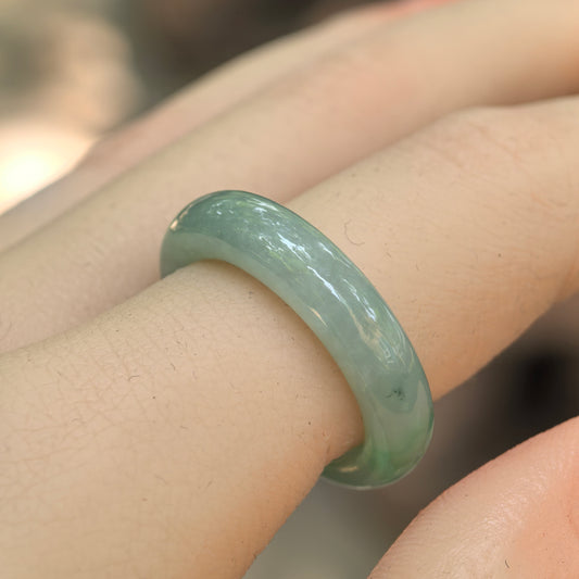 Natural Grade-A icy glutinous light green jadeite ring band worn on a finger, showing its smooth rounded profile.