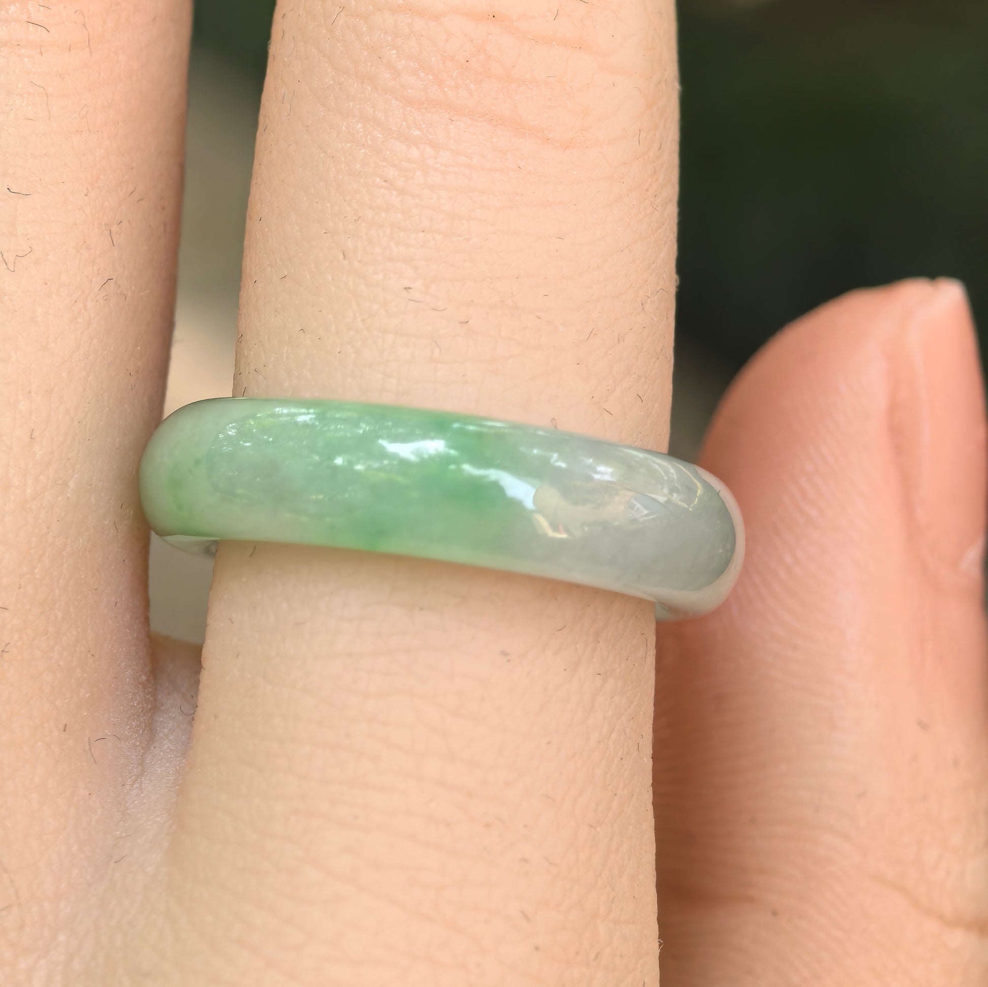 Close-up wearing view of the NGTC-certified light green Burmese jadeite ring band with good translucency.