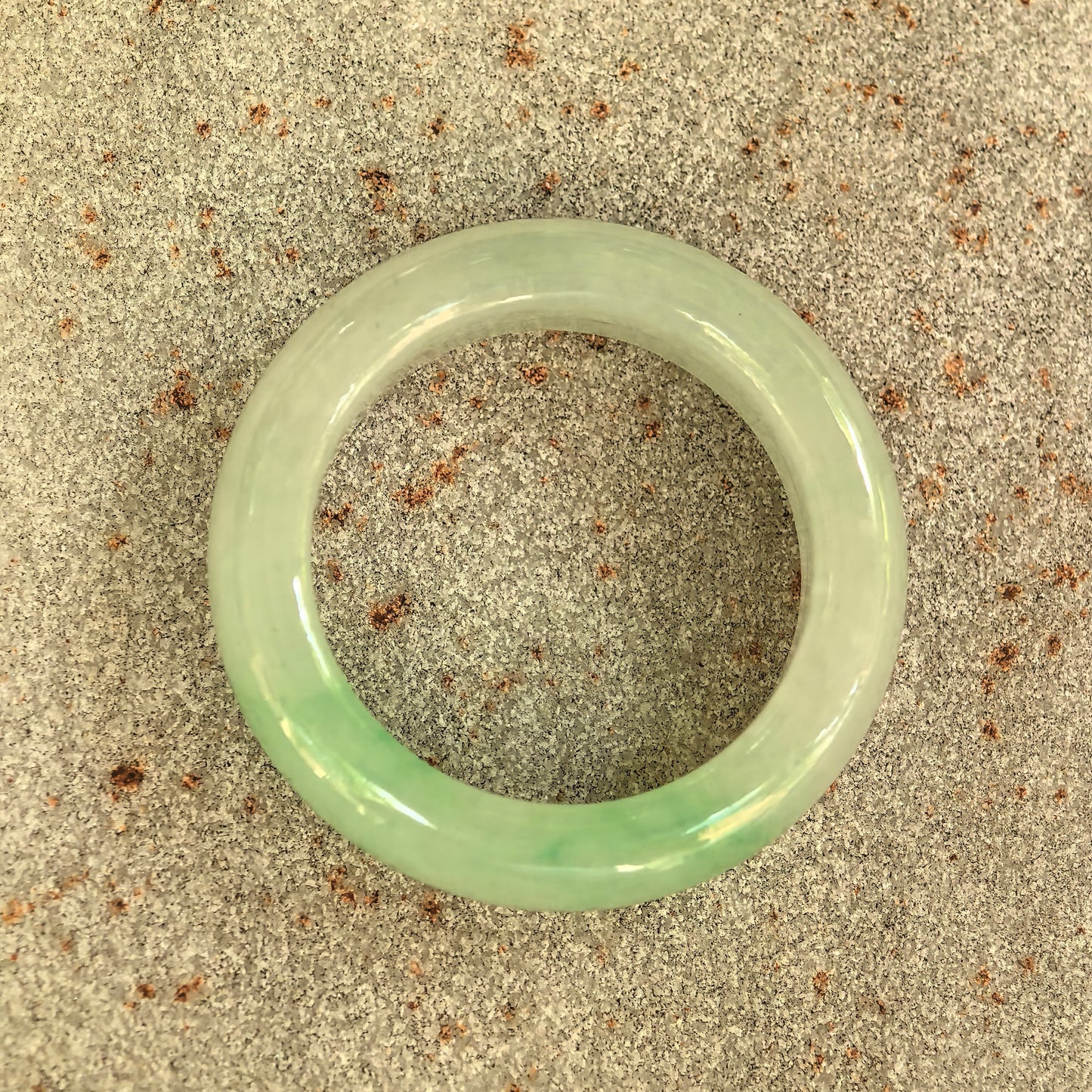 Top view of the NGTC-certified natural Grade-A jadeite ring band showing its circular form and green color distribution.