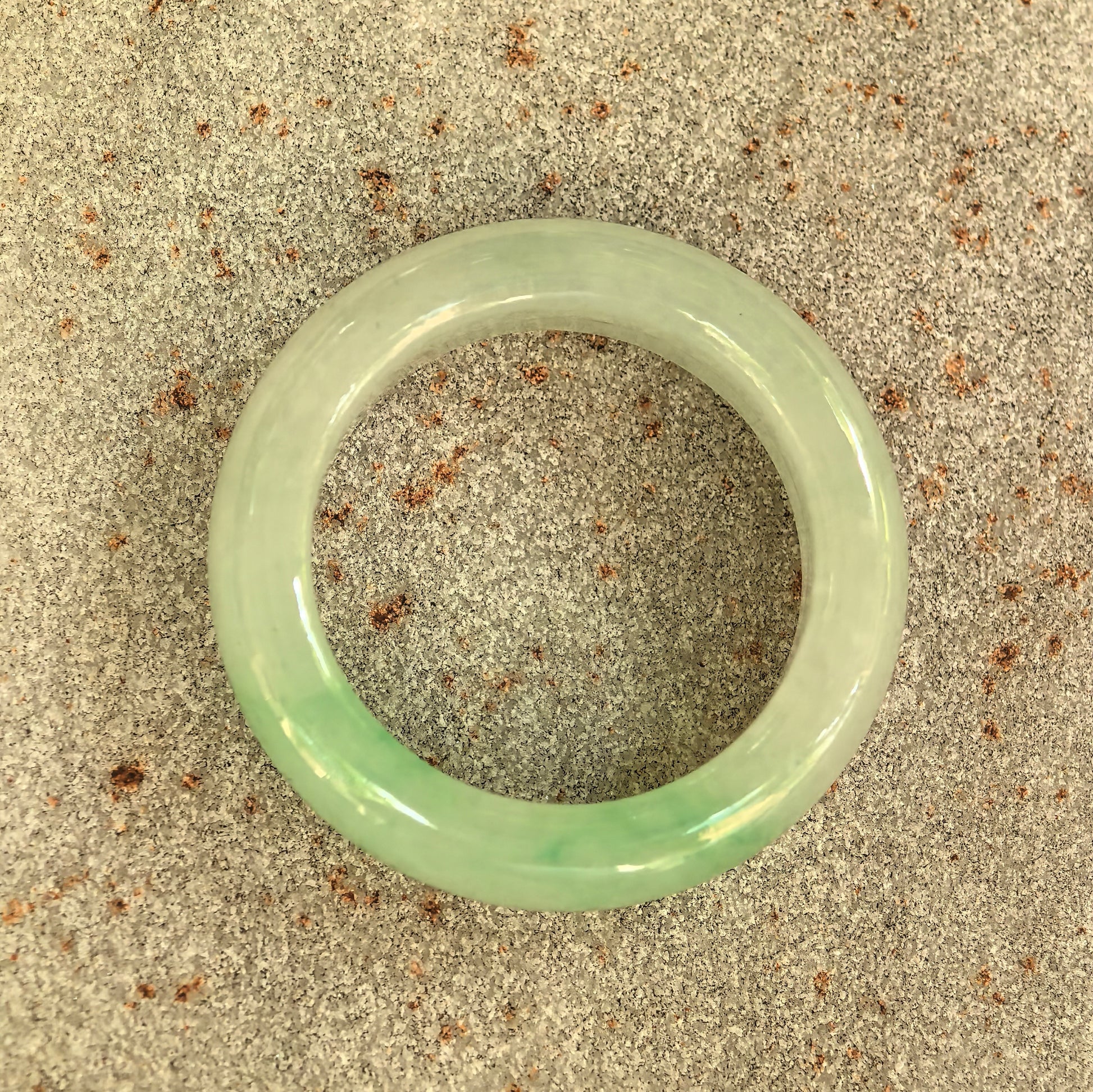 Top view of the NGTC-certified natural Grade-A jadeite ring band showing its circular form and green color distribution.