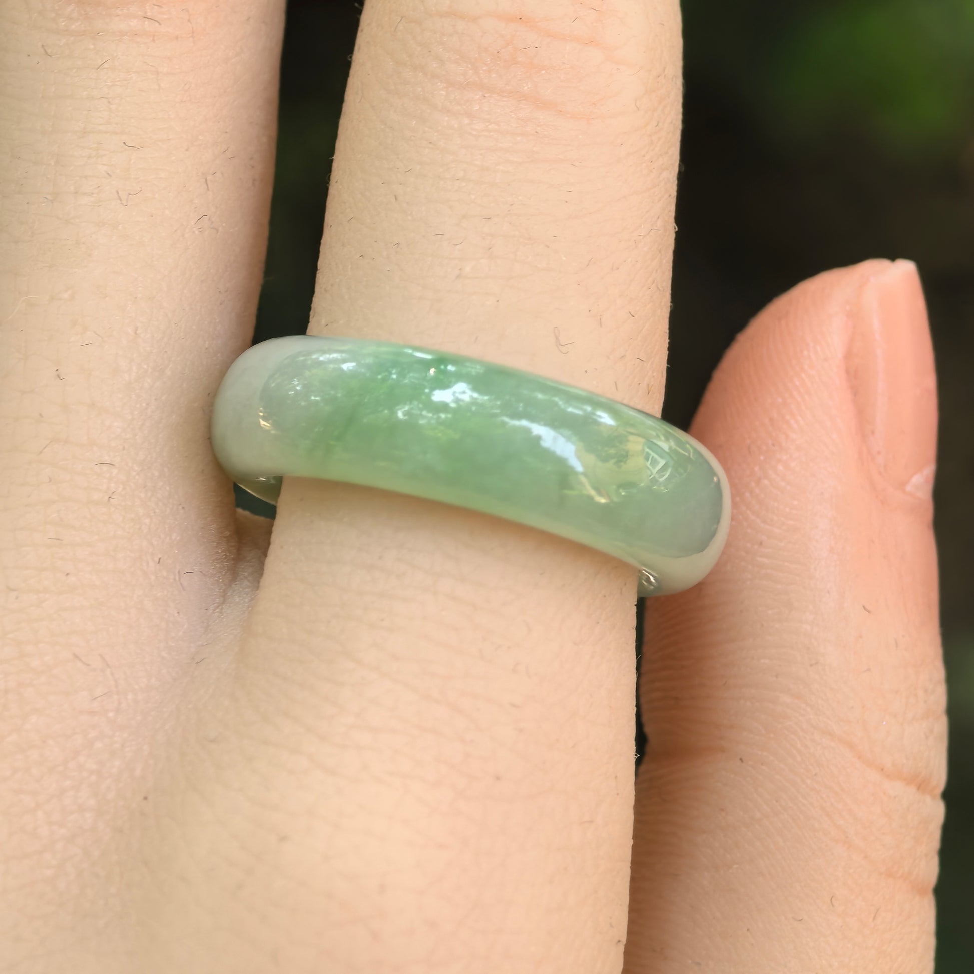 Close-up wearing view of the NGTC-certified light green Burmese jadeite ring band with good translucency.