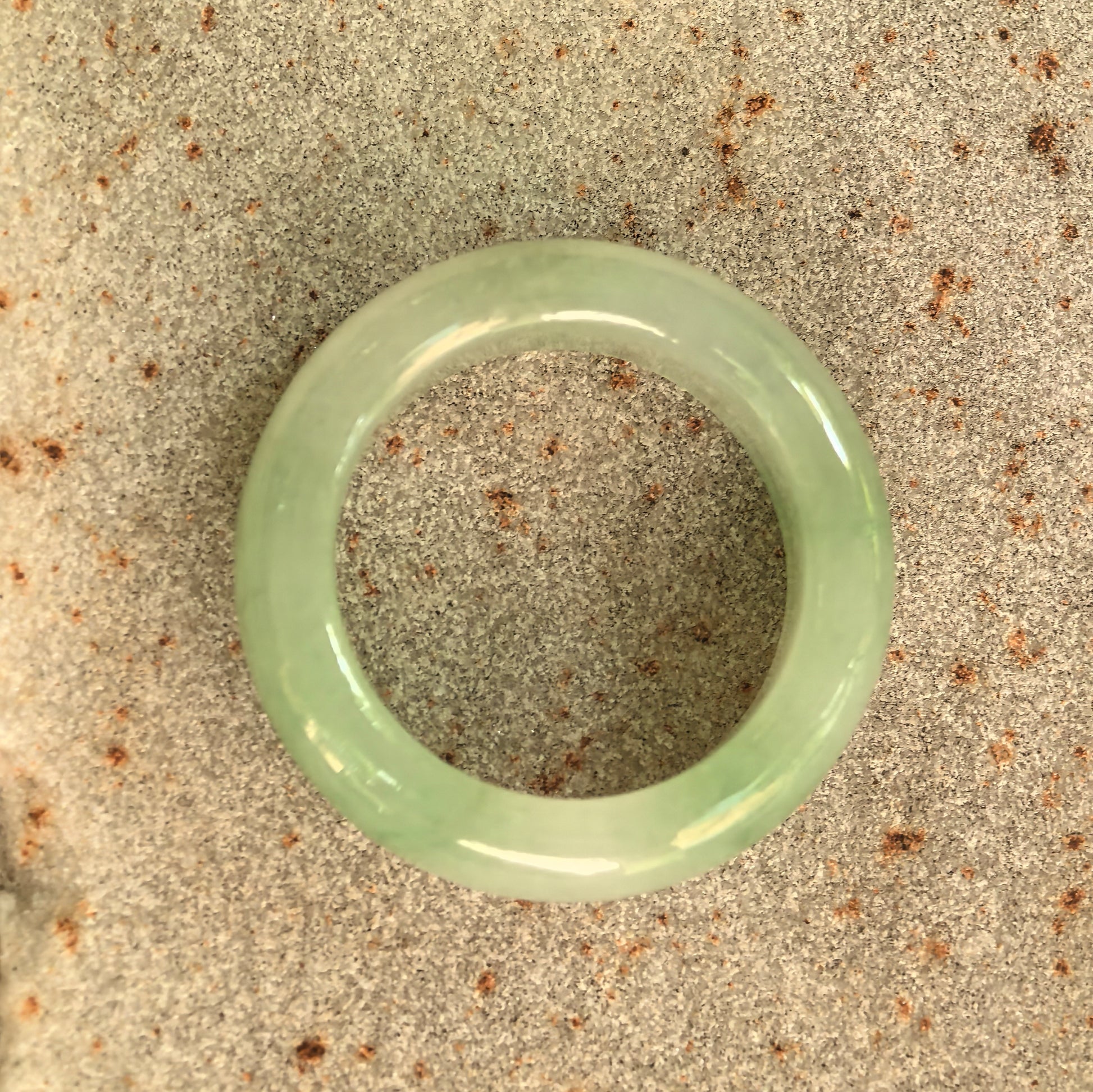Top view of the NGTC-certified natural Grade-A jadeite ring band showing its circular shape and soft green color.