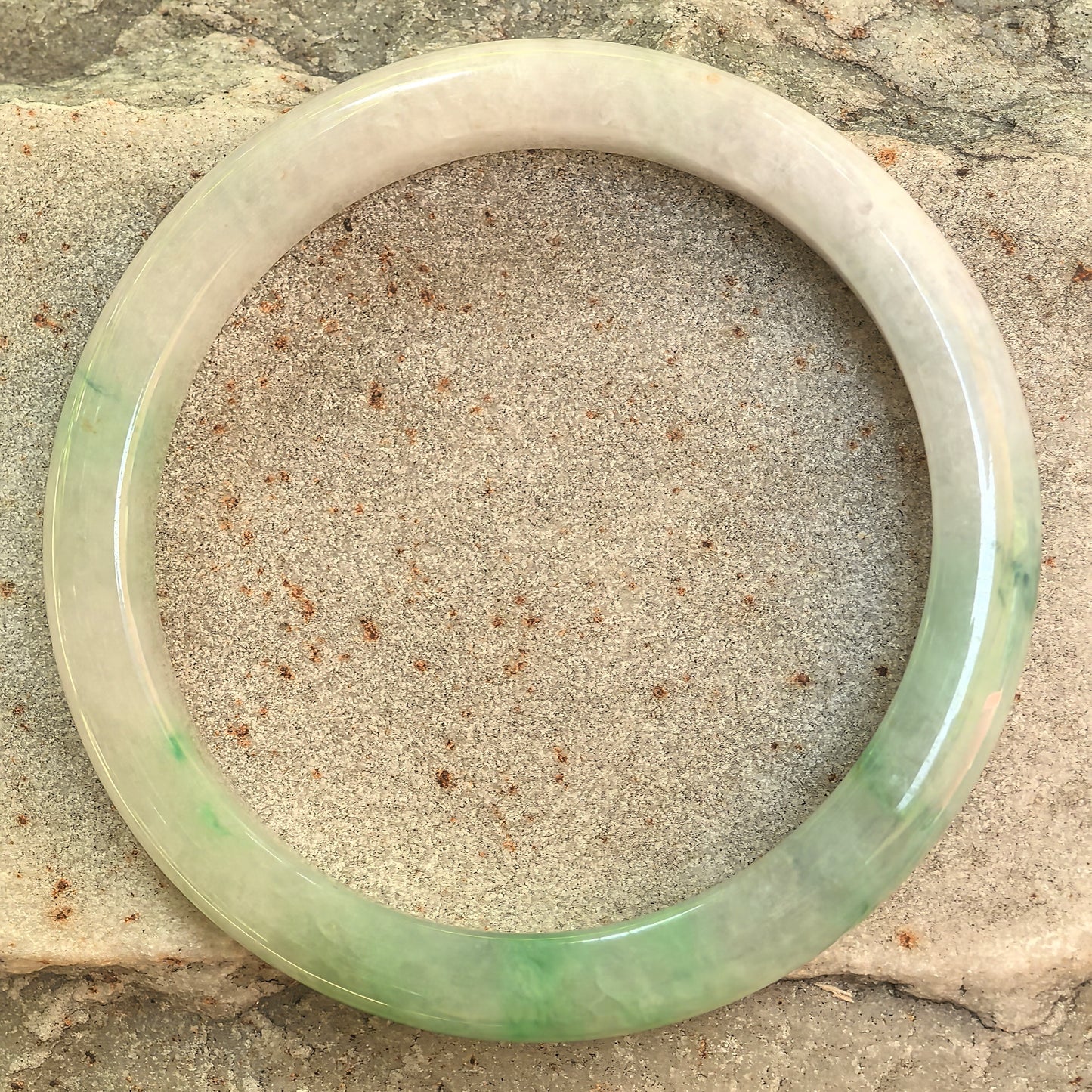 Top view of the white-base green jadeite bangle showing its natural color distribution.