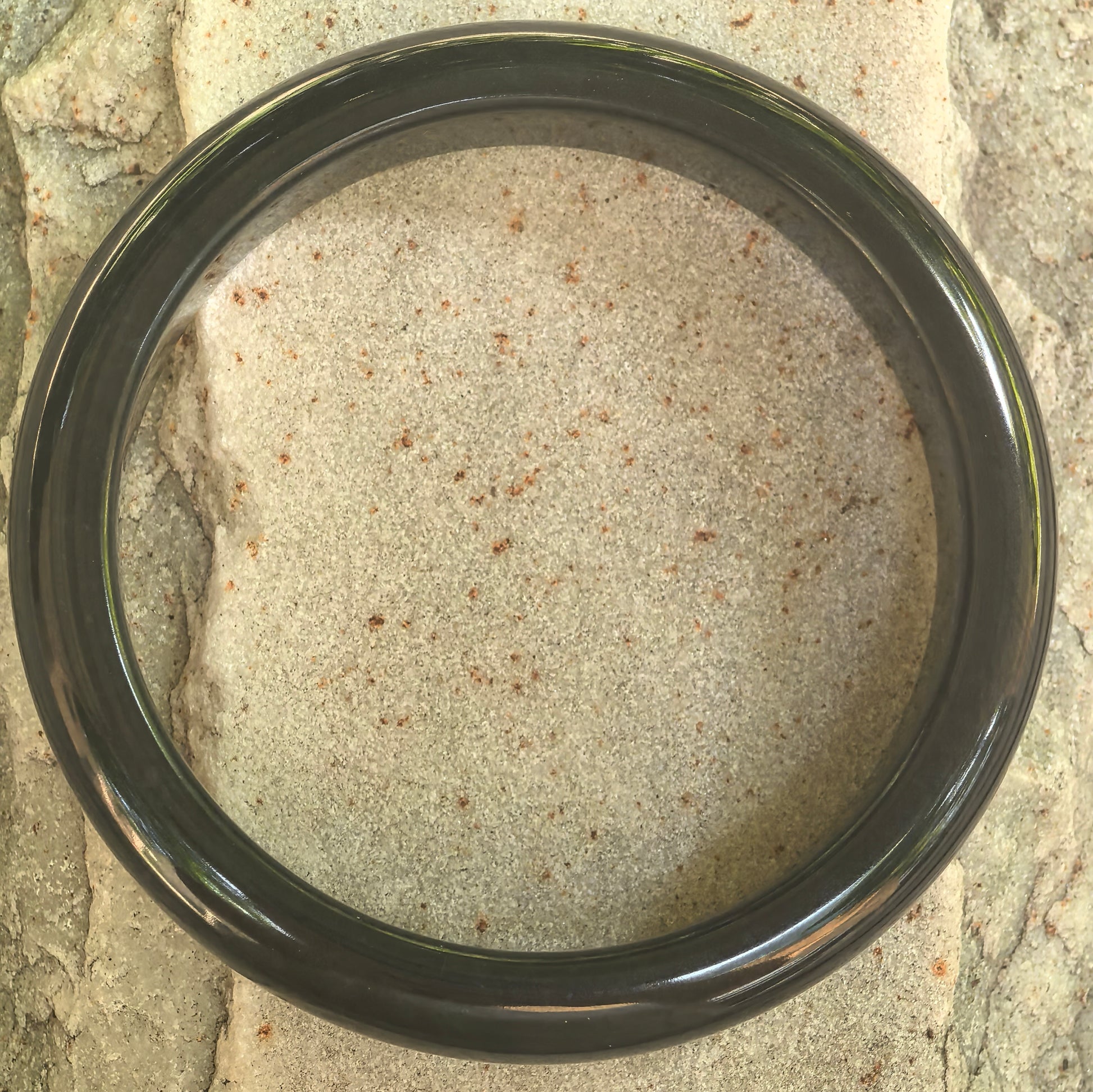 Top view of the natural Grade-A gray-black jadeite bangle showing its circular form and polished finish.