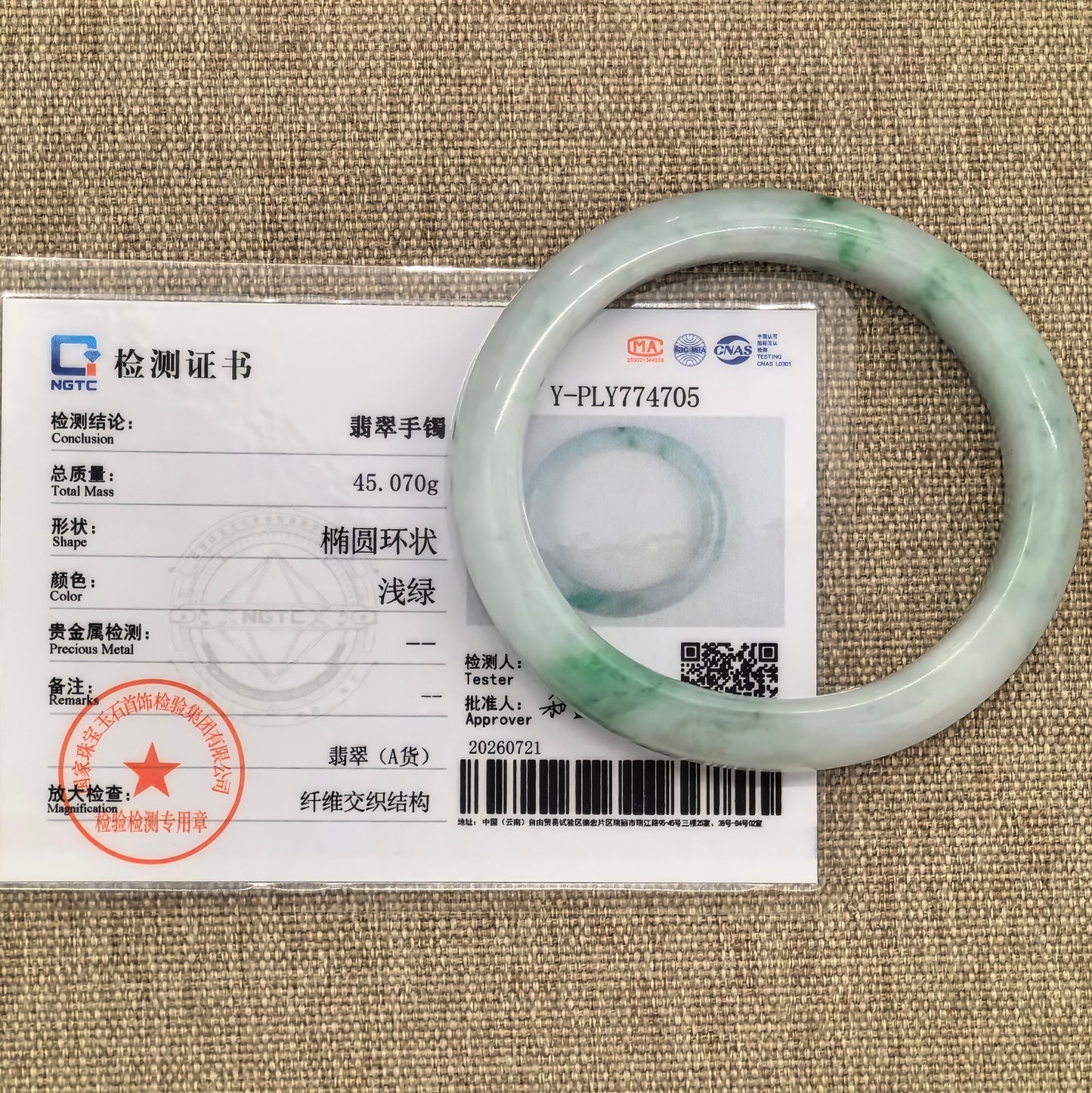 NGTC-certified glutinous white-base green jadeite bangle shown with its matching authentication certificate.