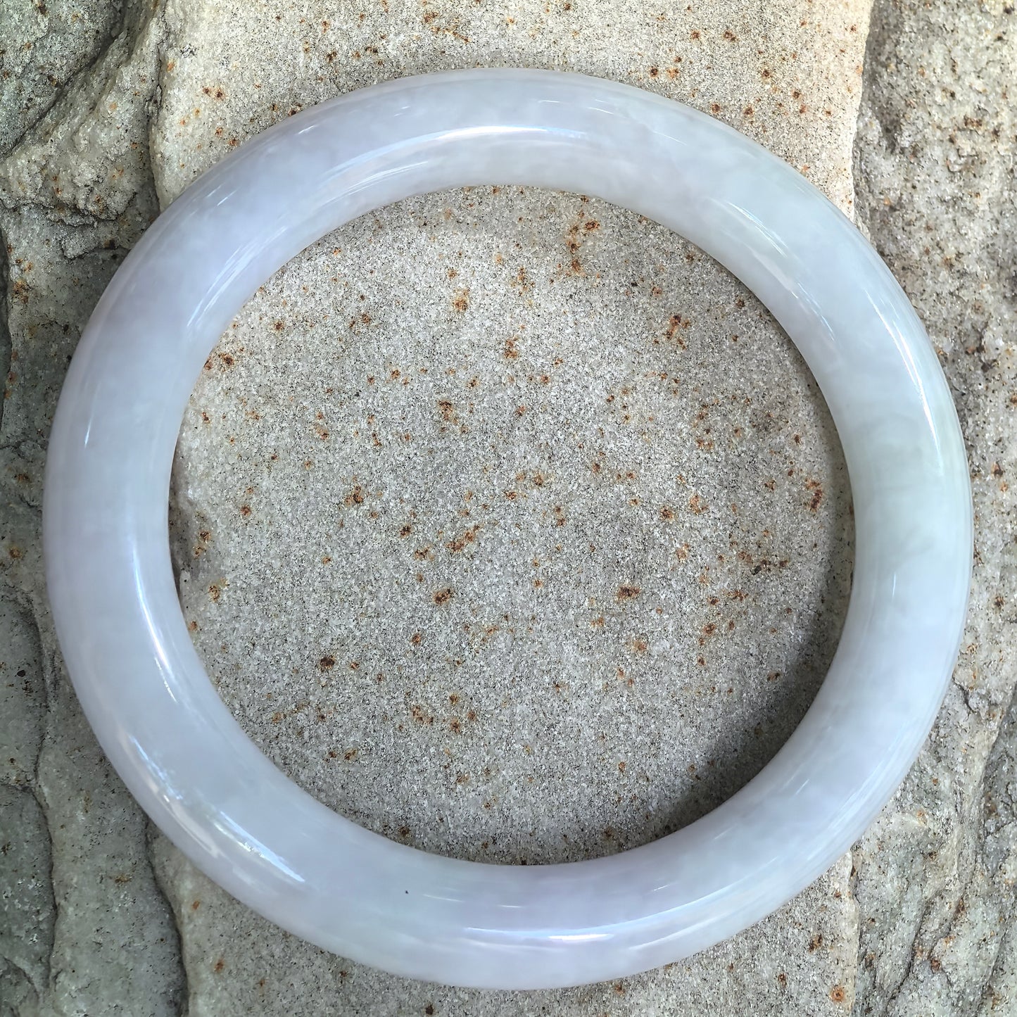 Top view of the natural Grade-A round-bar jadeite bangle showing its pale spring color and polished finish.