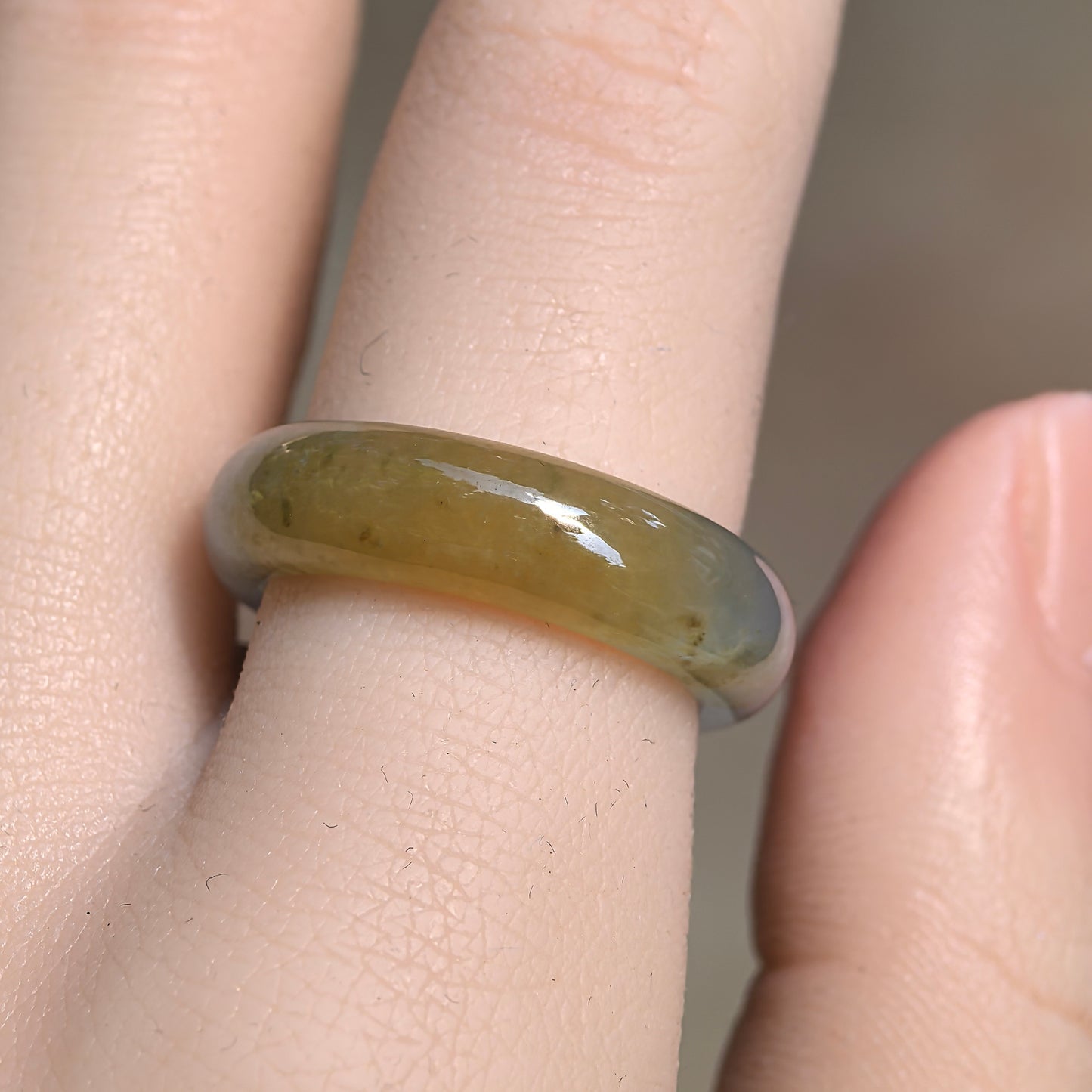 Close-up front view of the two-tone Burmese jadeite ring band showing its smooth rounded profile and translucent texture.