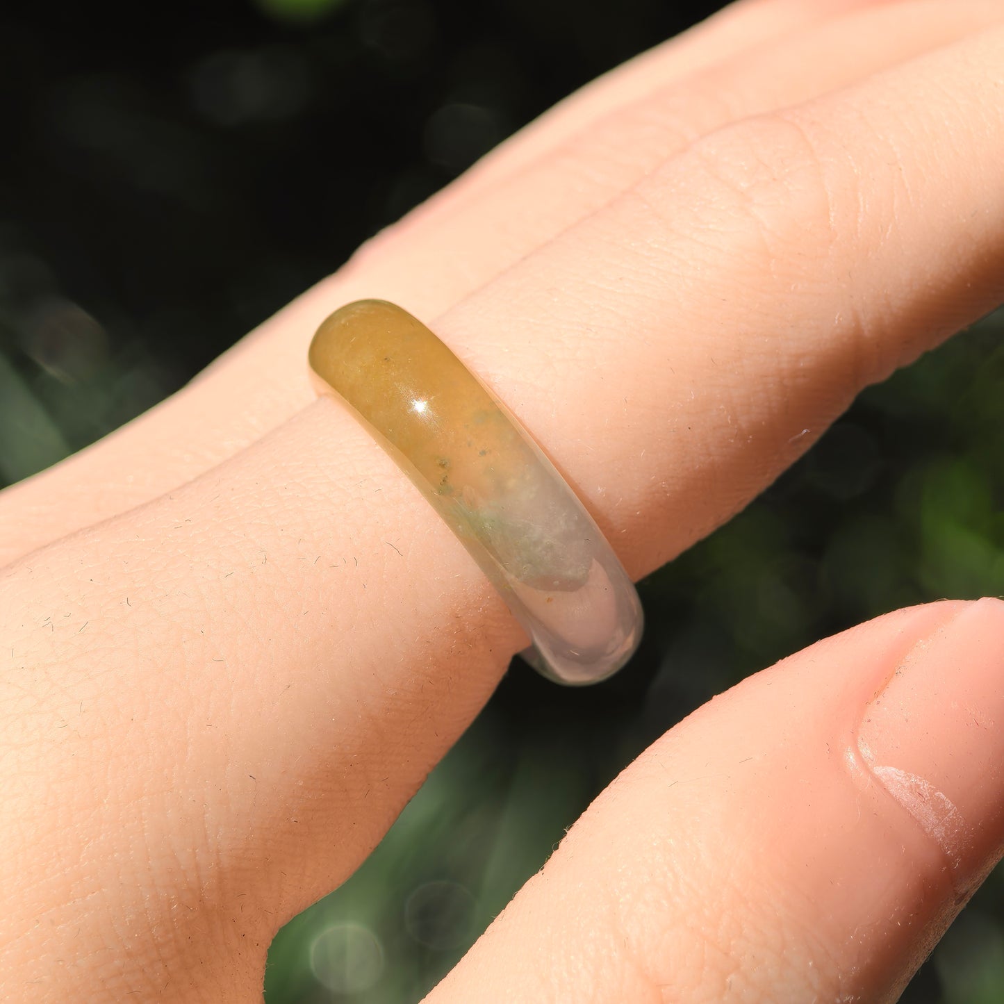 Natural light wearing view of the icy glutinous jadeite ring band with brownish-yellow and gray-green sections.