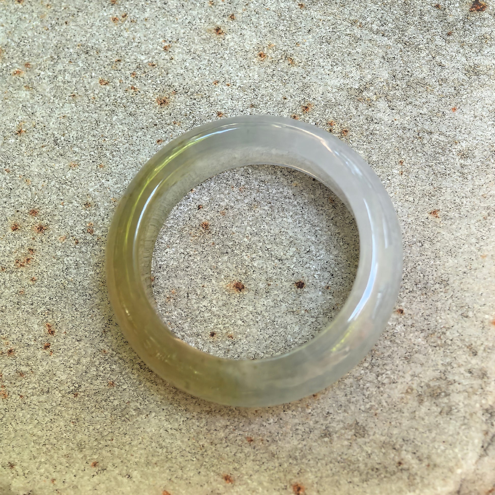 Top view of the half-yellow jadeite ring band showing its circular shape, pale green section, and natural color distribution.
