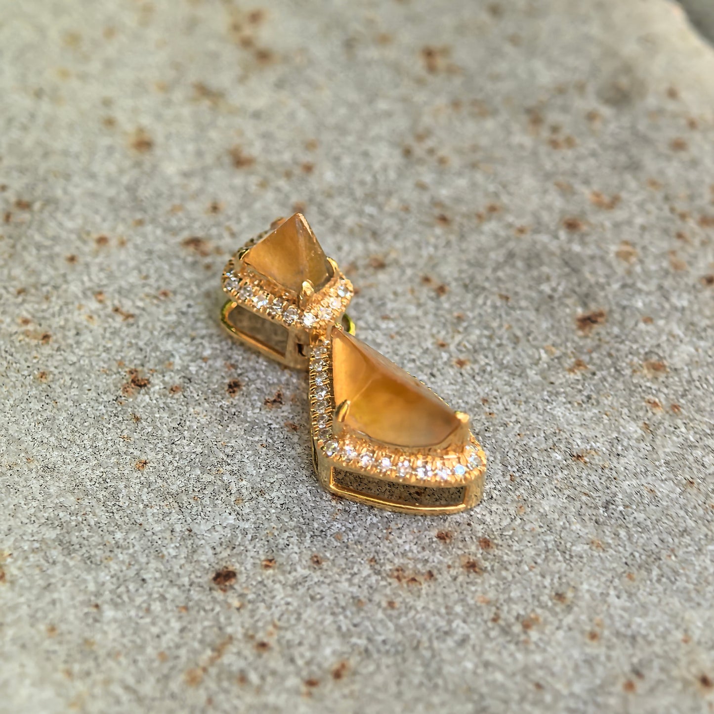Side detail of the icy yellow jadeite pendant showing the raised freeform cuts, 18K gold frame, and diamond border.