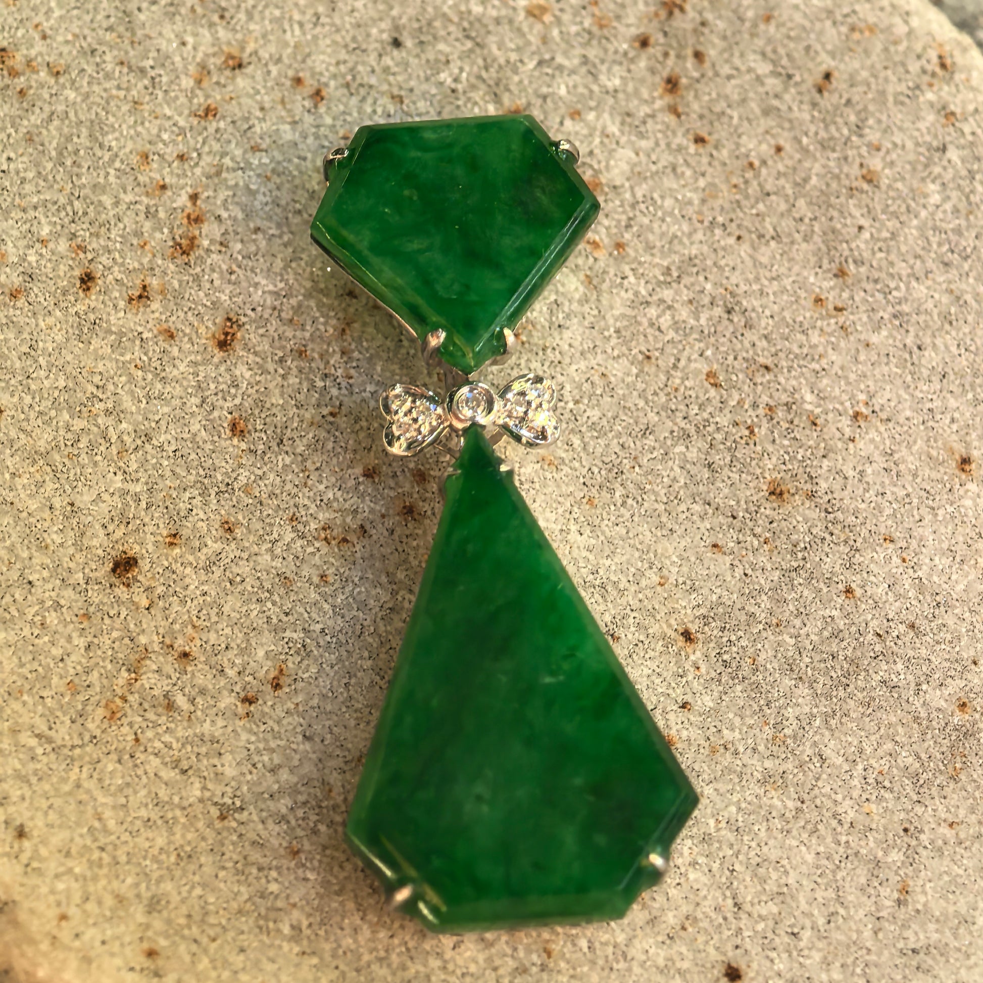 Front detail of the rich green geometric jadeite pendant showing its articulated drop structure and diamond-set 18K gold design.