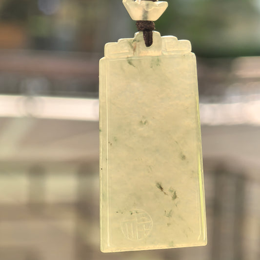 Natural Grade-A icy glutinous light green plain plaque jadeite pendant hanging on its woven cord in natural backlight.