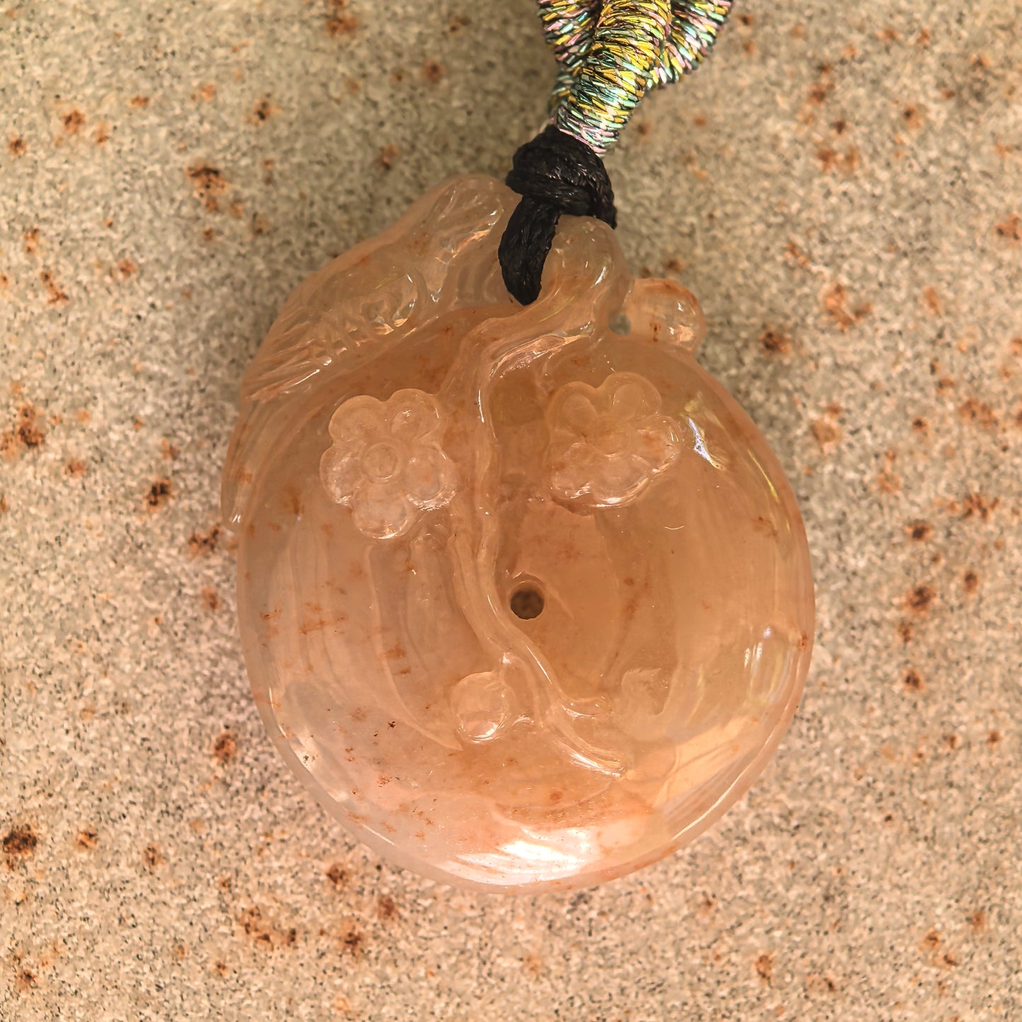 Front detail of the warm yellow jadeite pendant showing the dimensional plum blossom branch and flower carving.