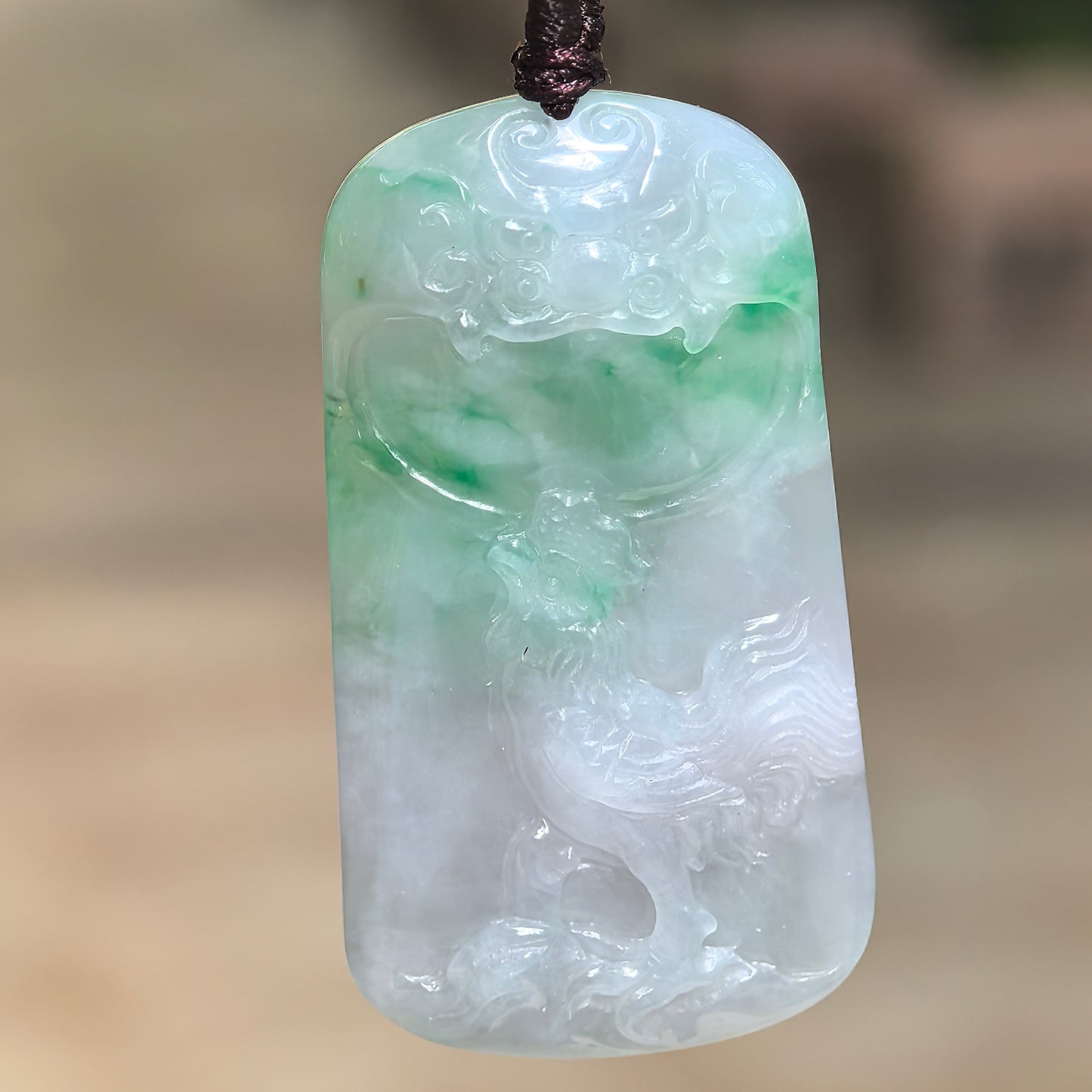 Natural Grade-A glutinous white-and-green rooster plaque jadeite pendant hanging from its cord and showing detailed relief carving.