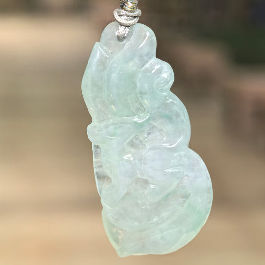 Natural Grade-A icy glutinous light green nine-tailed fox jadeite pendant hanging from a woven cord.