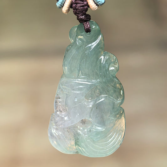 Natural Grade-A icy glutinous deep green nine-tailed fox jadeite pendant hanging from its decorative cord.