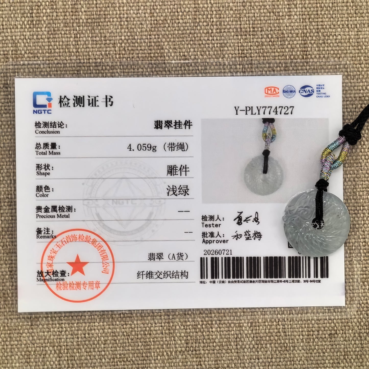 NGTC-certified icy white dragon round jadeite pendant shown with its matching certificate and woven cord.