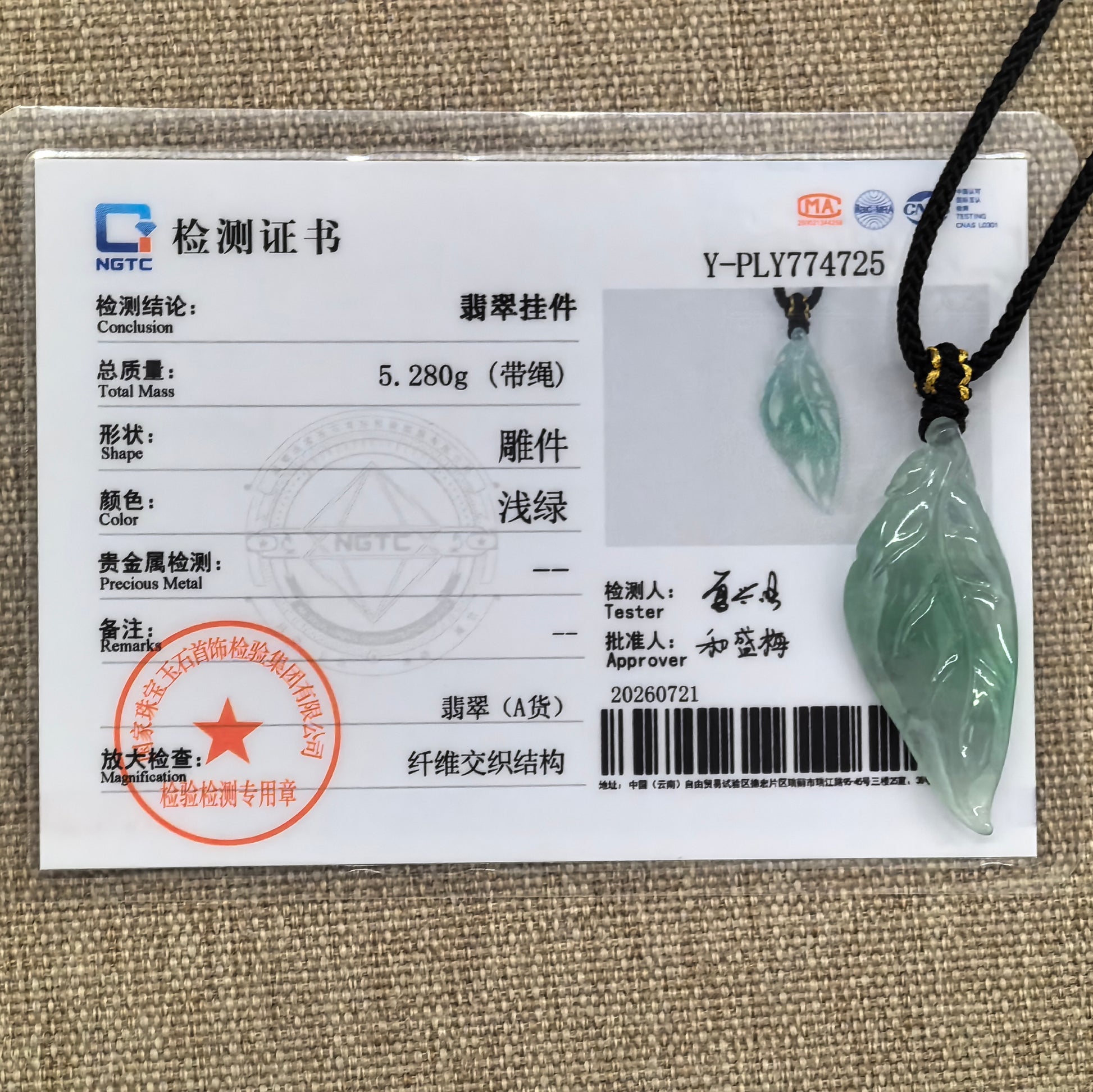 NGTC-certified light green leaf jadeite pendant shown with its matching certificate and woven cord.