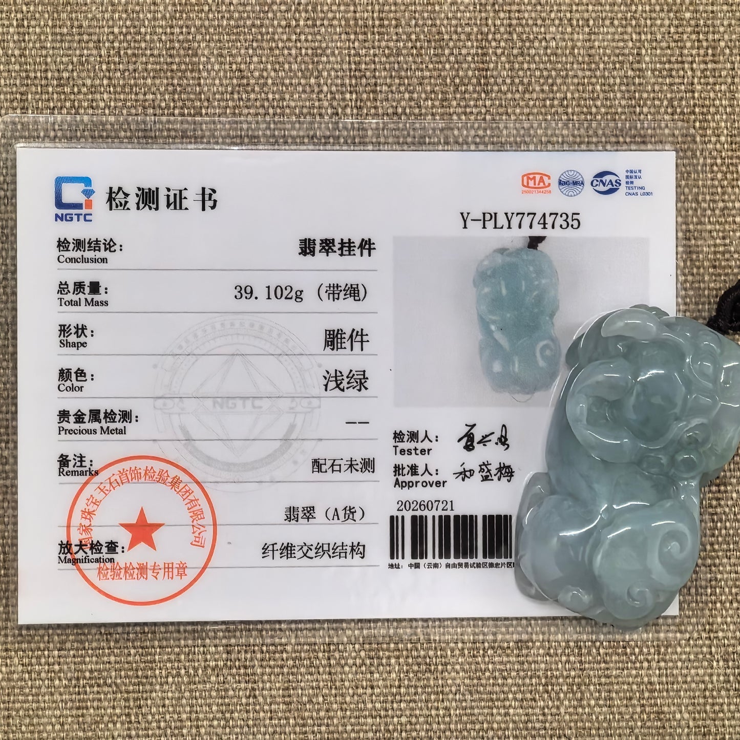 NGTC-certified blue-green Pixiu jadeite pendant displayed with its matching certificate, decorative cord, and accessory beads.