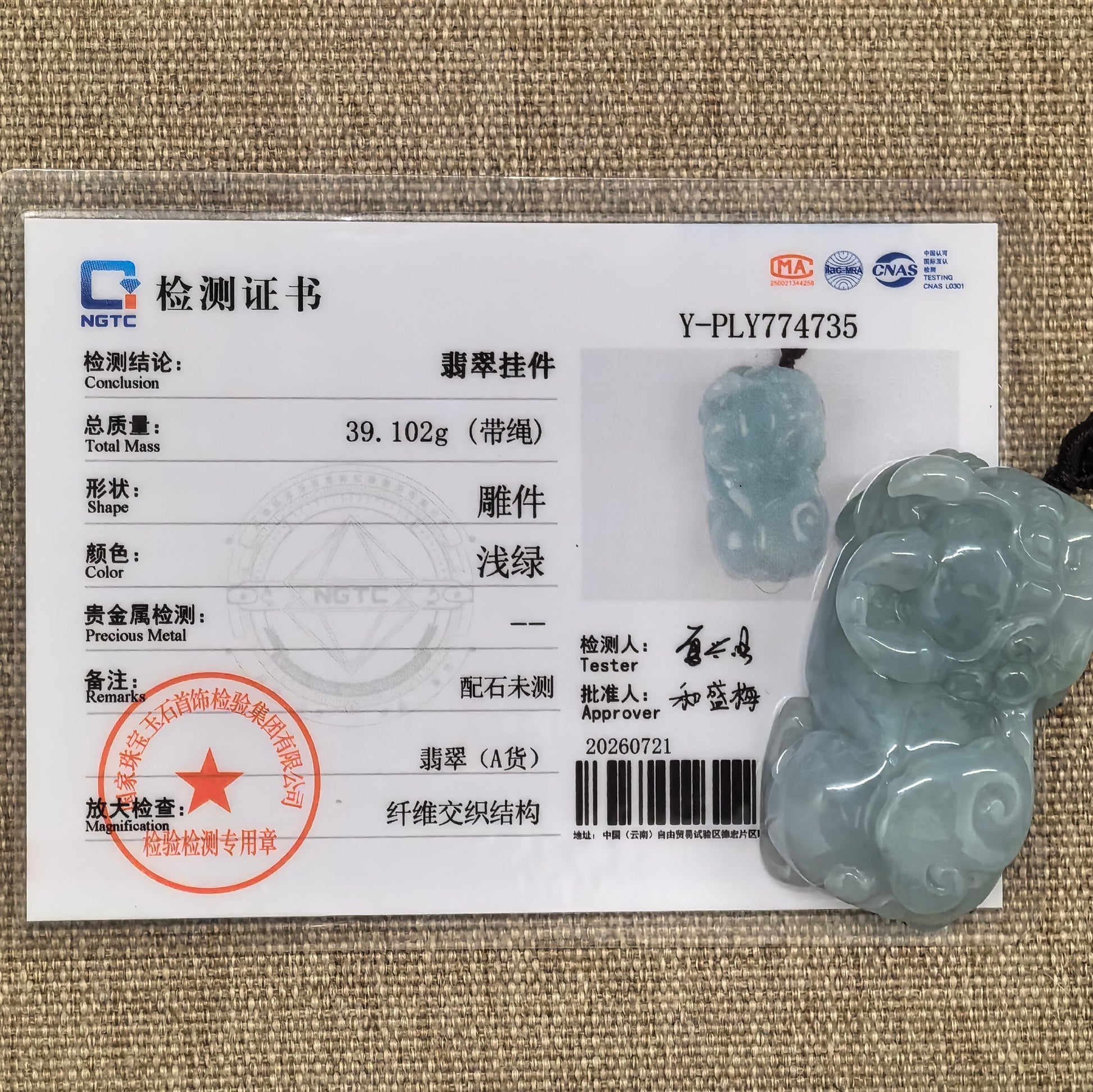 NGTC-certified blue-green Pixiu jadeite pendant displayed with its matching certificate, decorative cord, and accessory beads.