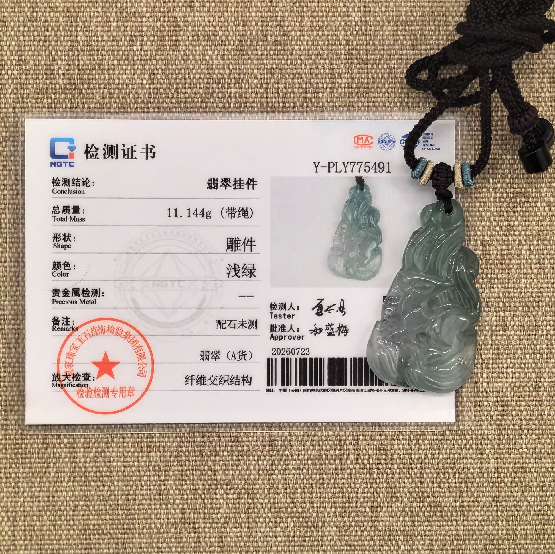 NGTC-certified deep green nine-tailed fox jadeite pendant displayed with its matching certificate and decorative cord.