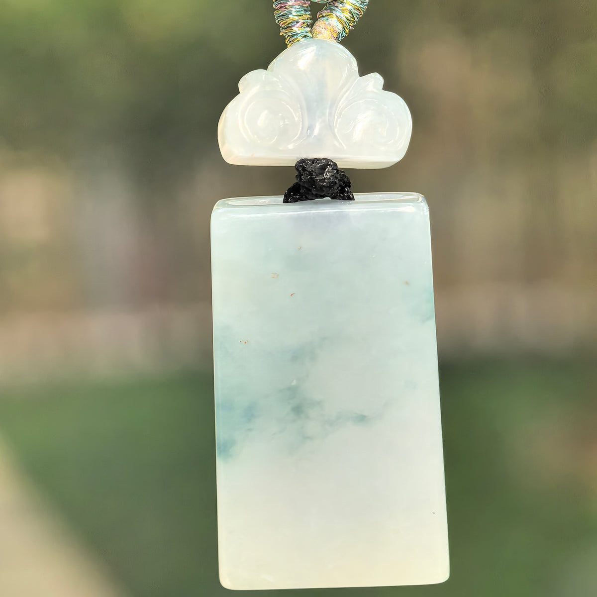 Natural Grade-A icy glutinous light green plain plaque jadeite pendant with an auspicious cloud-shaped spacer.