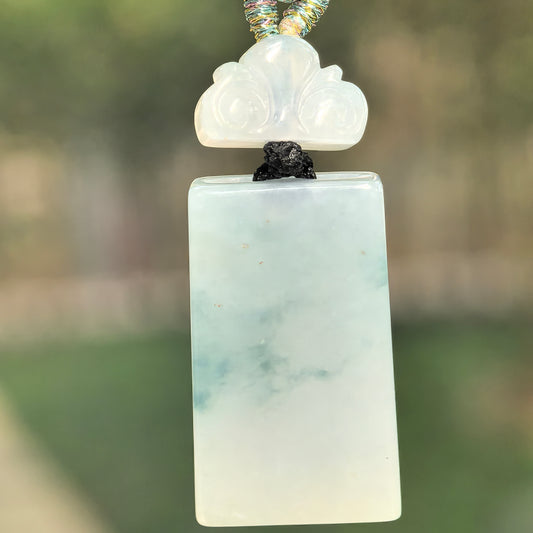 Natural Grade-A icy glutinous light green plain plaque jadeite pendant with an auspicious cloud-shaped spacer.