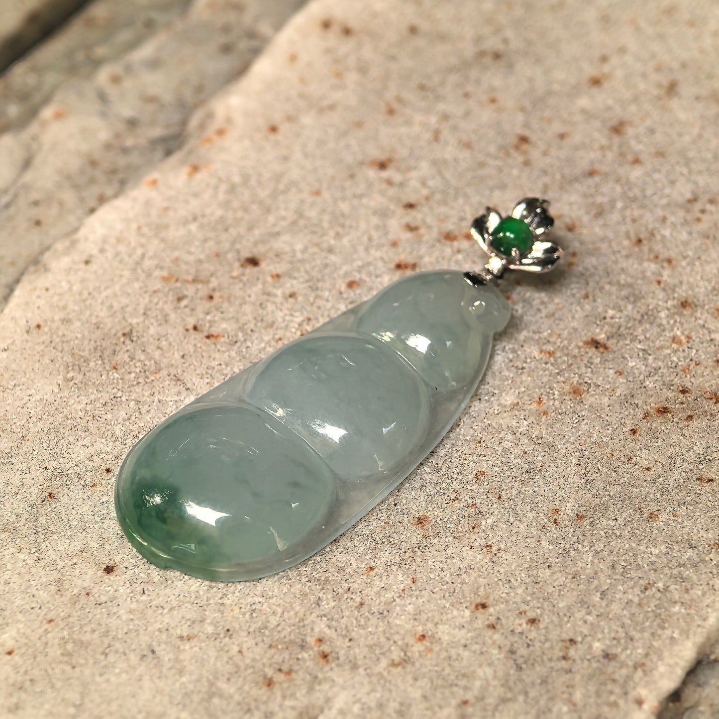 Close-up of the icy glutinous bean jadeite pendant showing its curved surface and good translucency.