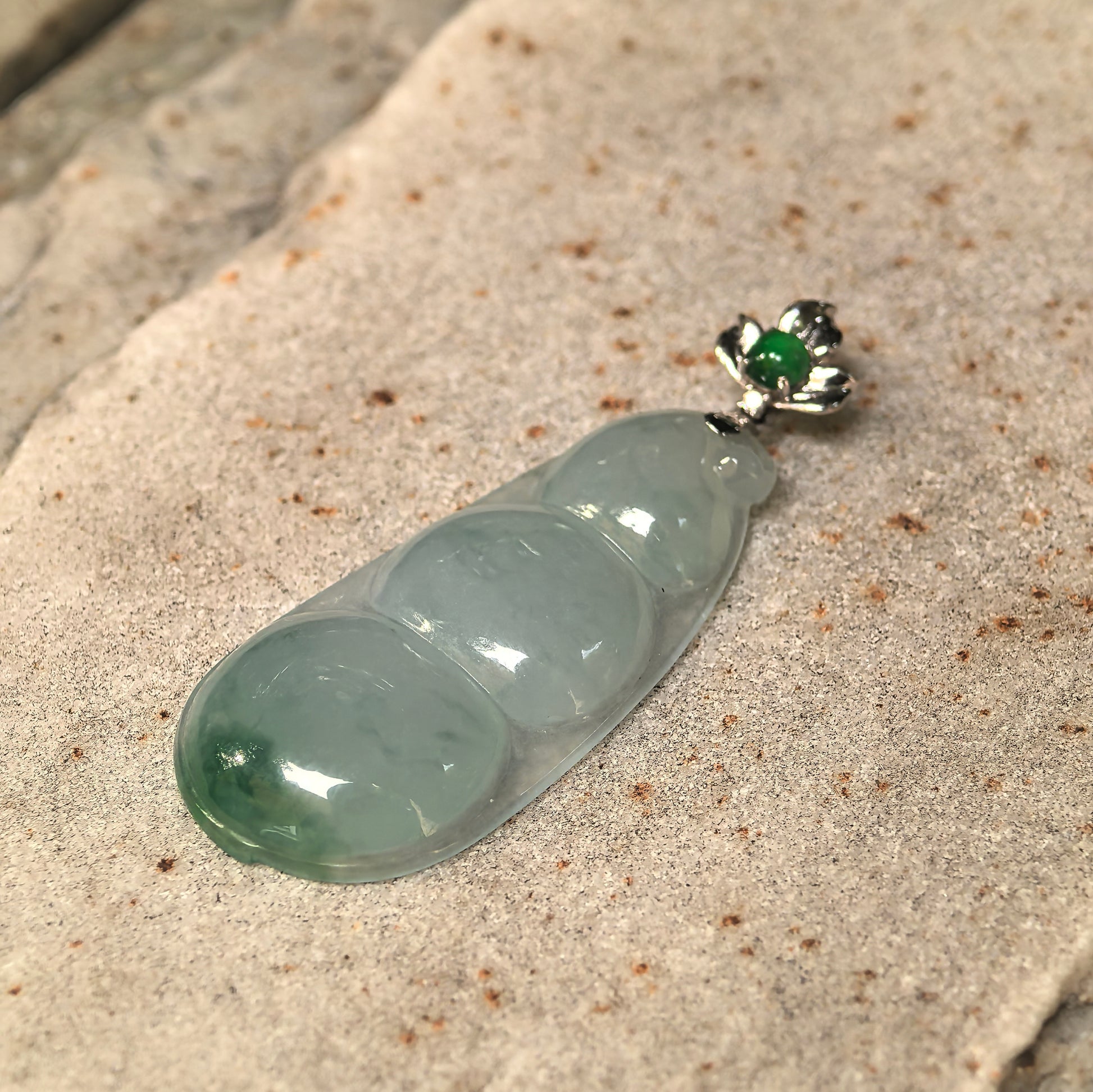 Close-up of the icy glutinous bean jadeite pendant showing its curved surface and good translucency.
