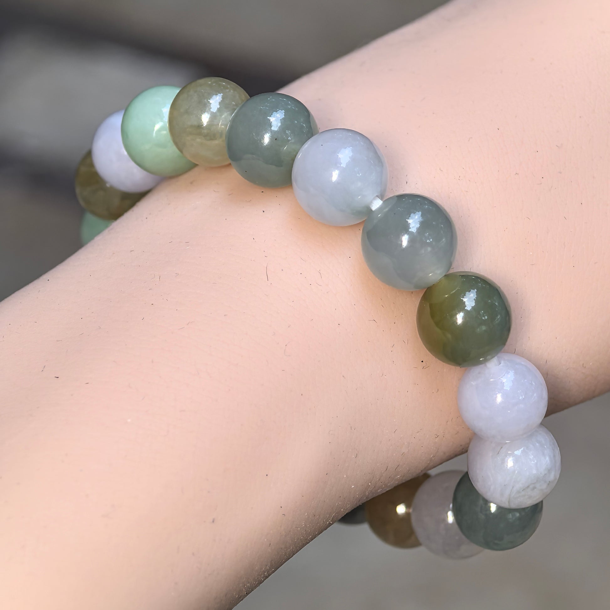 Close-up wearing view of a natural Grade-A icy glutinous multicolor jadeite bracelet with polished 10 mm round beads.