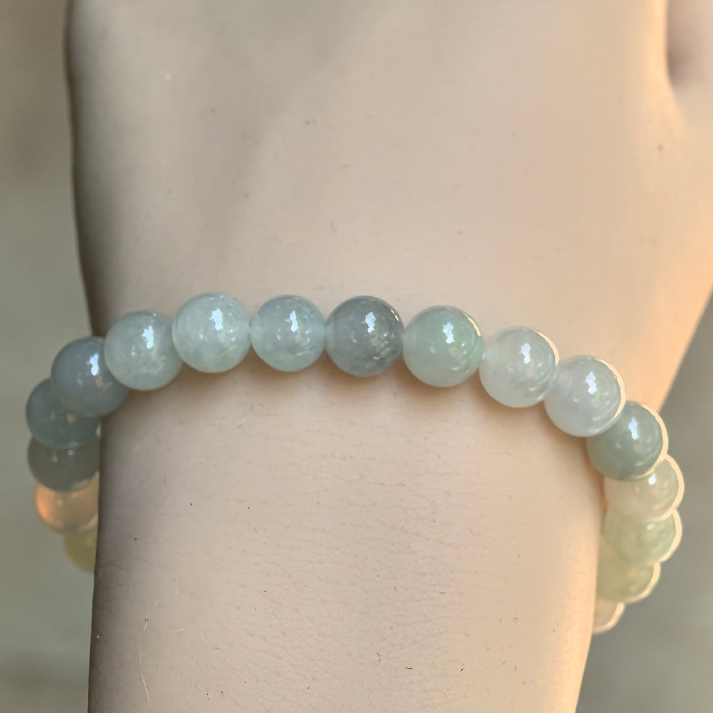 Front wrist view of the light green Burmese jadeite bracelet showing the soft color variation and smooth luster.
