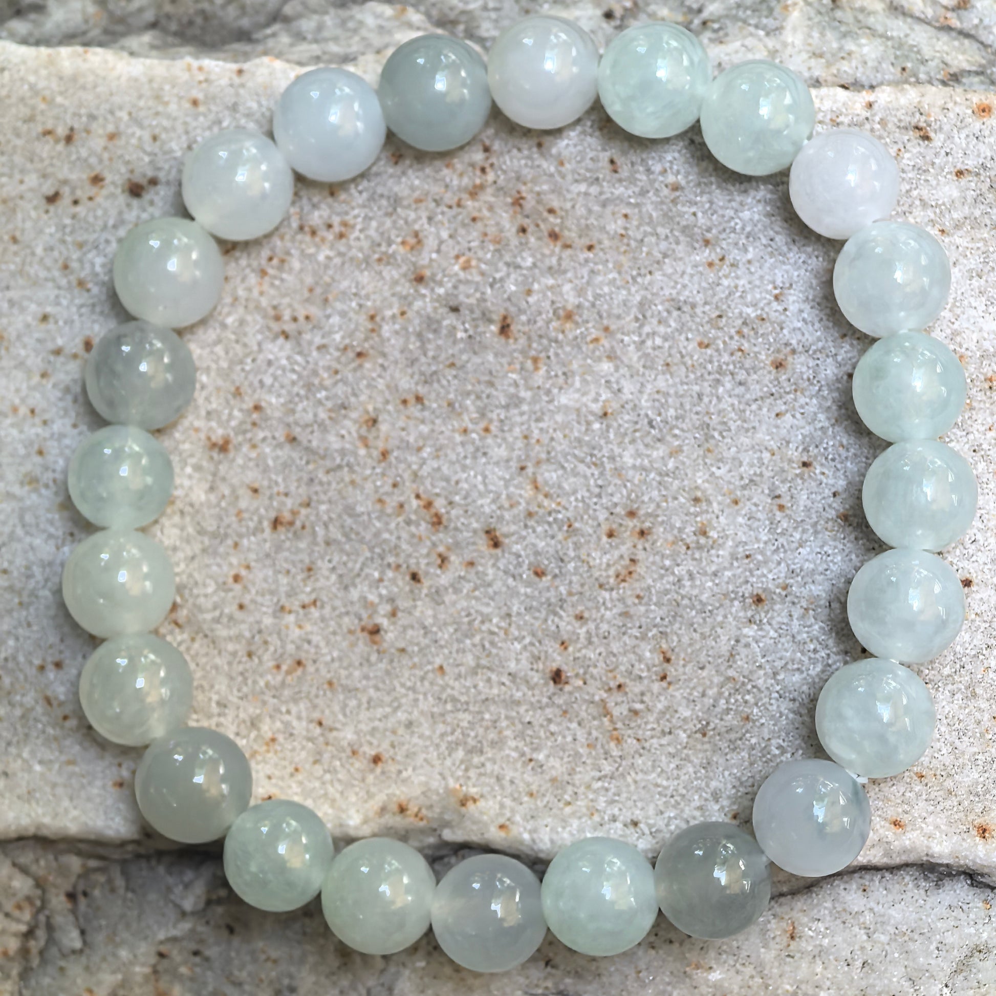 Top-down view of the icy glutinous jadeite bracelet showing all 24 polished 8 mm round beads.