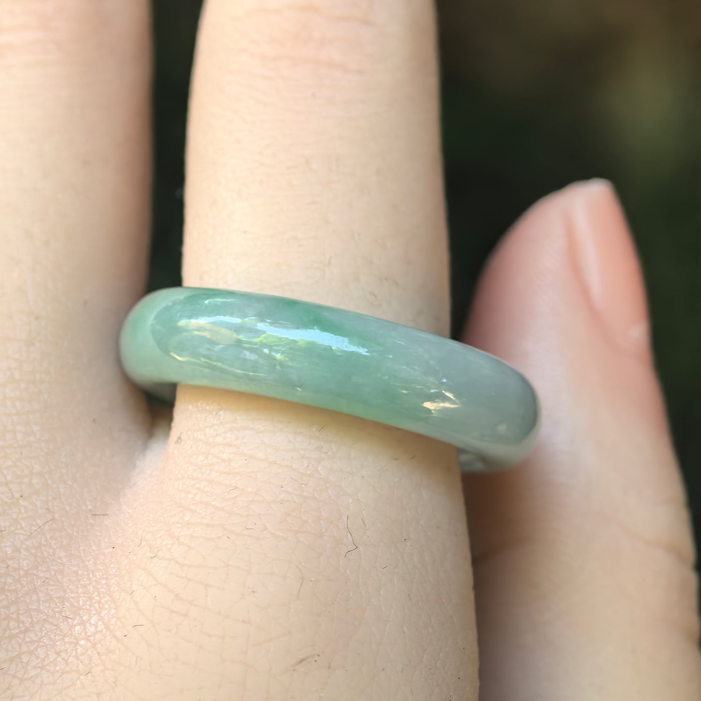 Side view of the light green Burmese jadeite ring band showing its rounded profile and smooth polish.