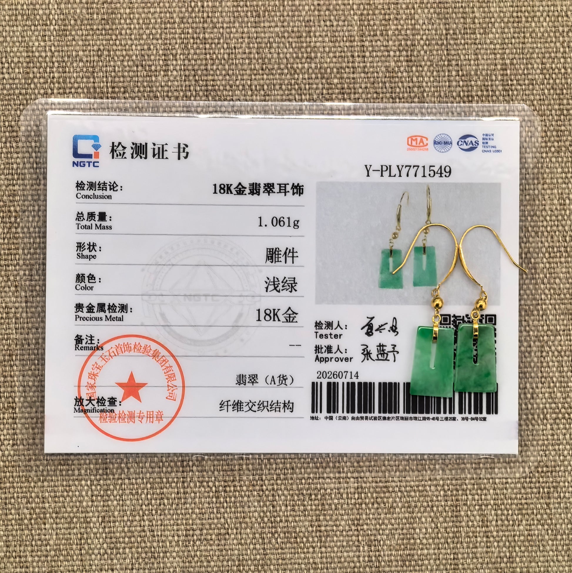 NGTC certified green jadeite drop earrings displayed with their matching certificate and documented 18K gold setting.