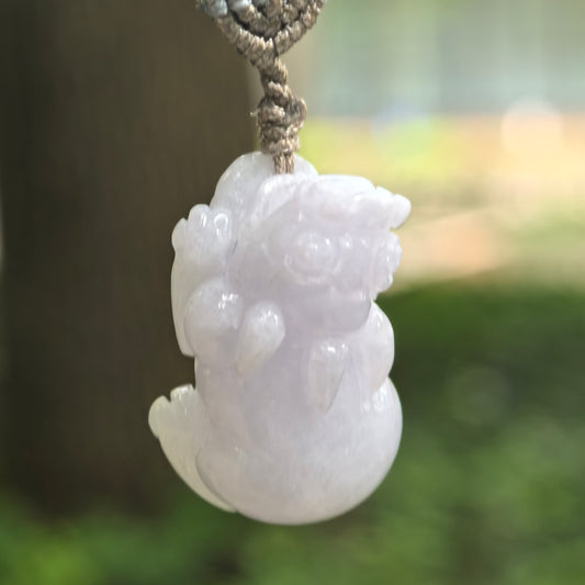 Natural Grade-A pale lavender Pixiu jadeite pendant hanging from its woven cord.
