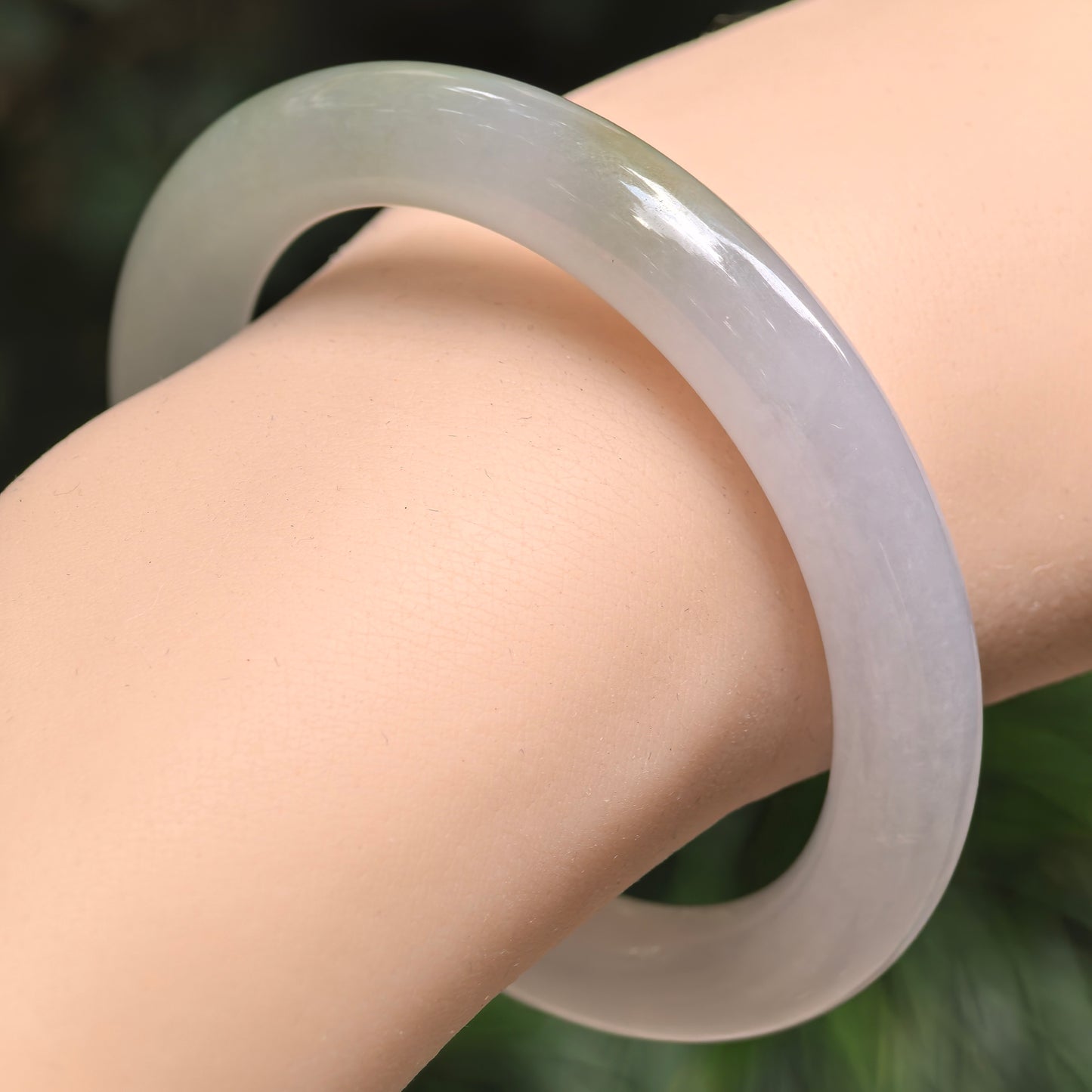 Fine icy glutinous lavender-green jadeite round bangle worn on the wrist, showing its soft translucency and polished luster.