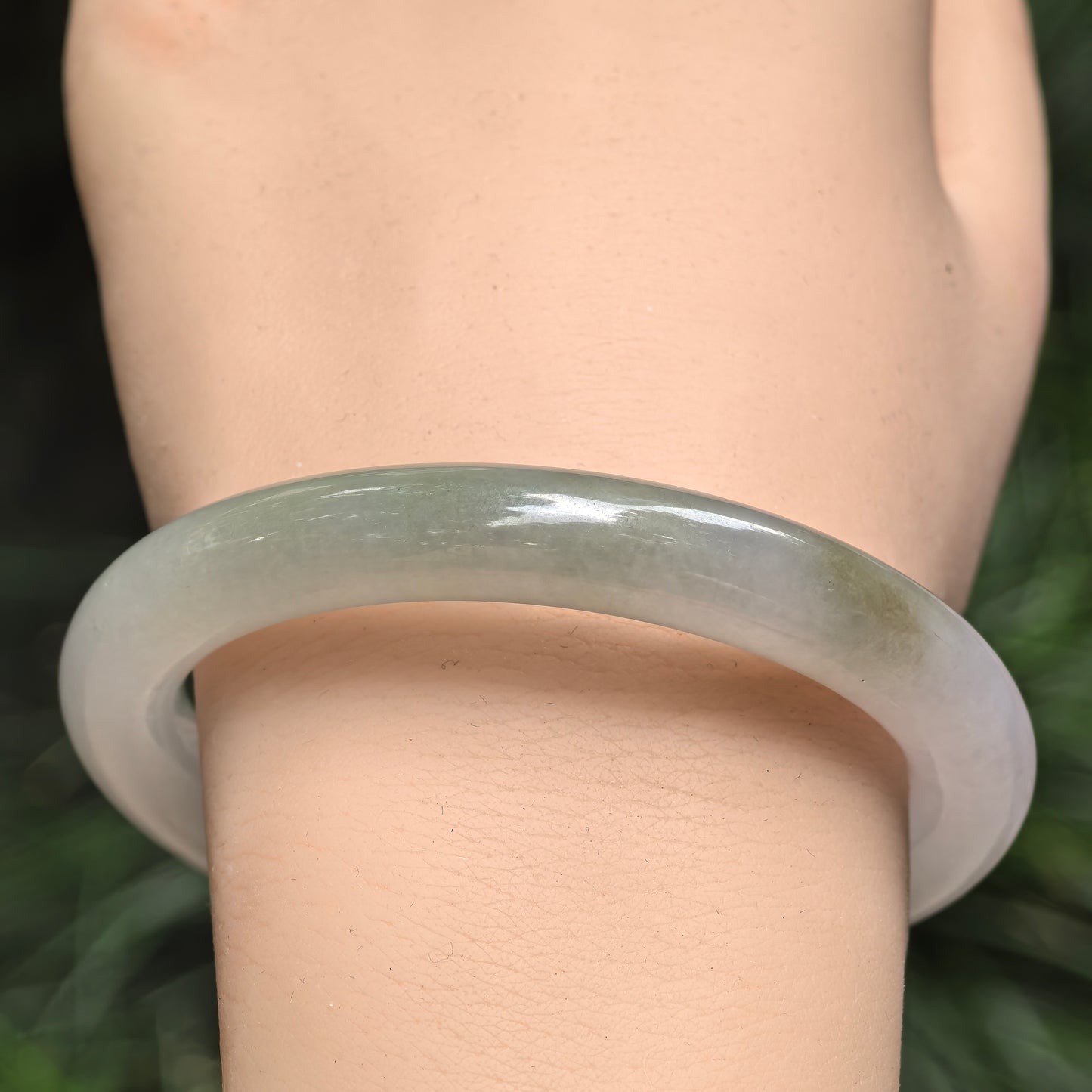 Natural Grade-A jadeite round bangle worn on the wrist, highlighting the pale lavender base and subtle green color variation.