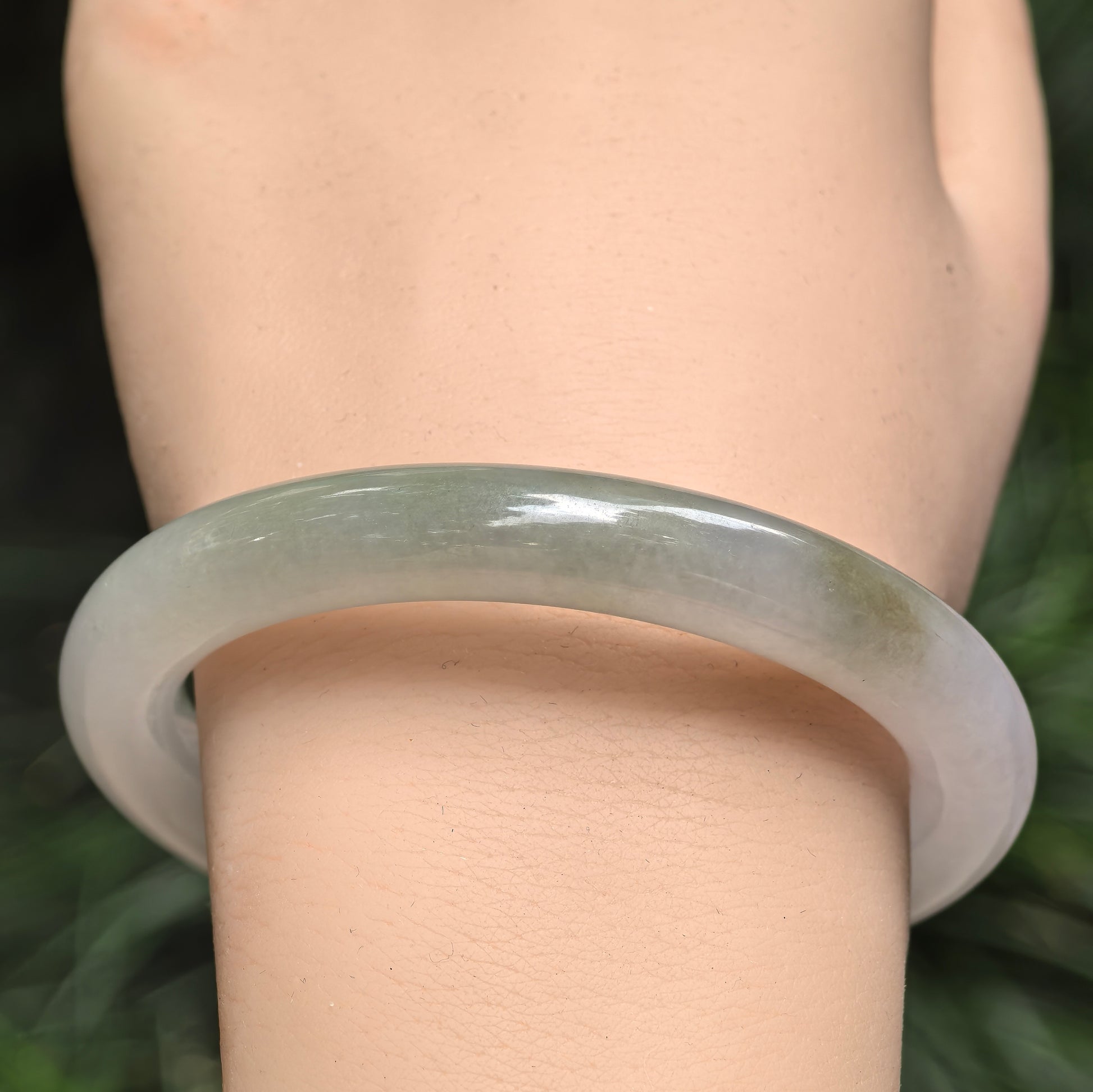 Natural Grade-A jadeite round bangle worn on the wrist, highlighting the pale lavender base and subtle green color variation.