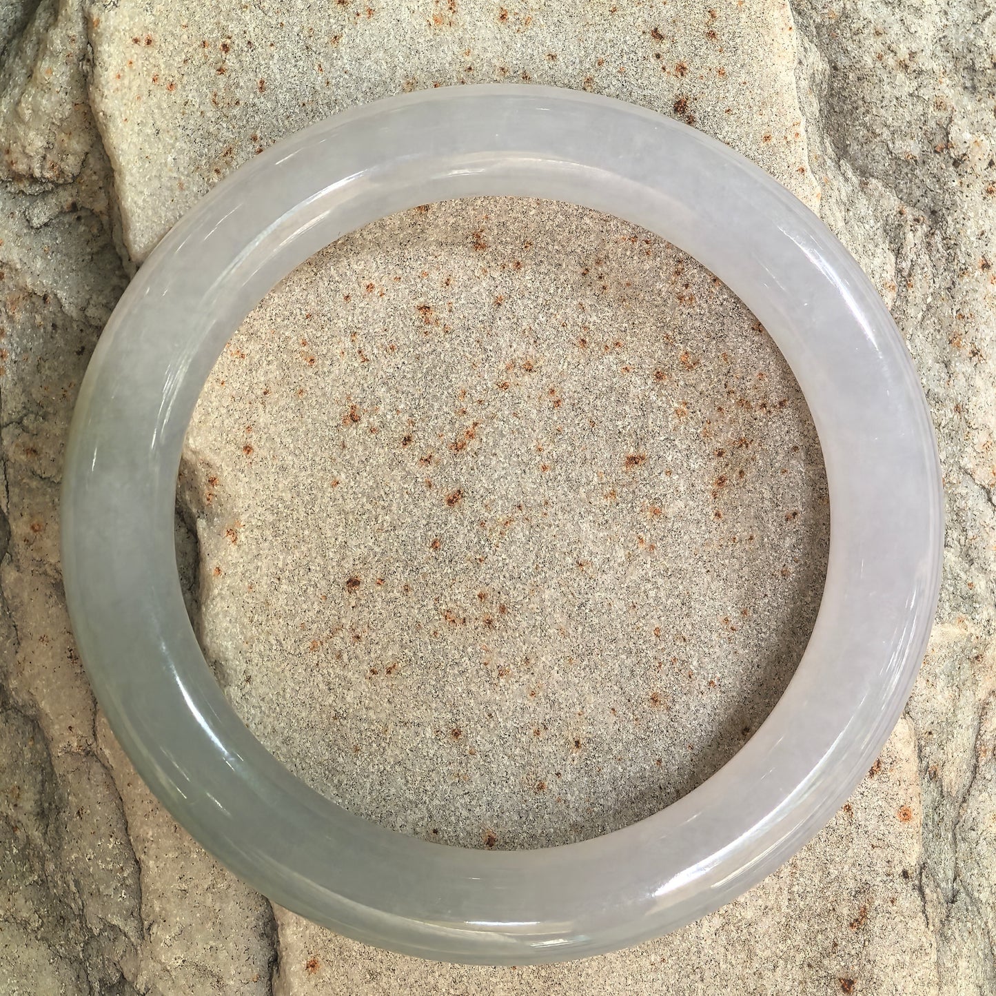 Top view of pale lavender and green Burmese jadeite round bangle showing the full circular profile and fine texture.