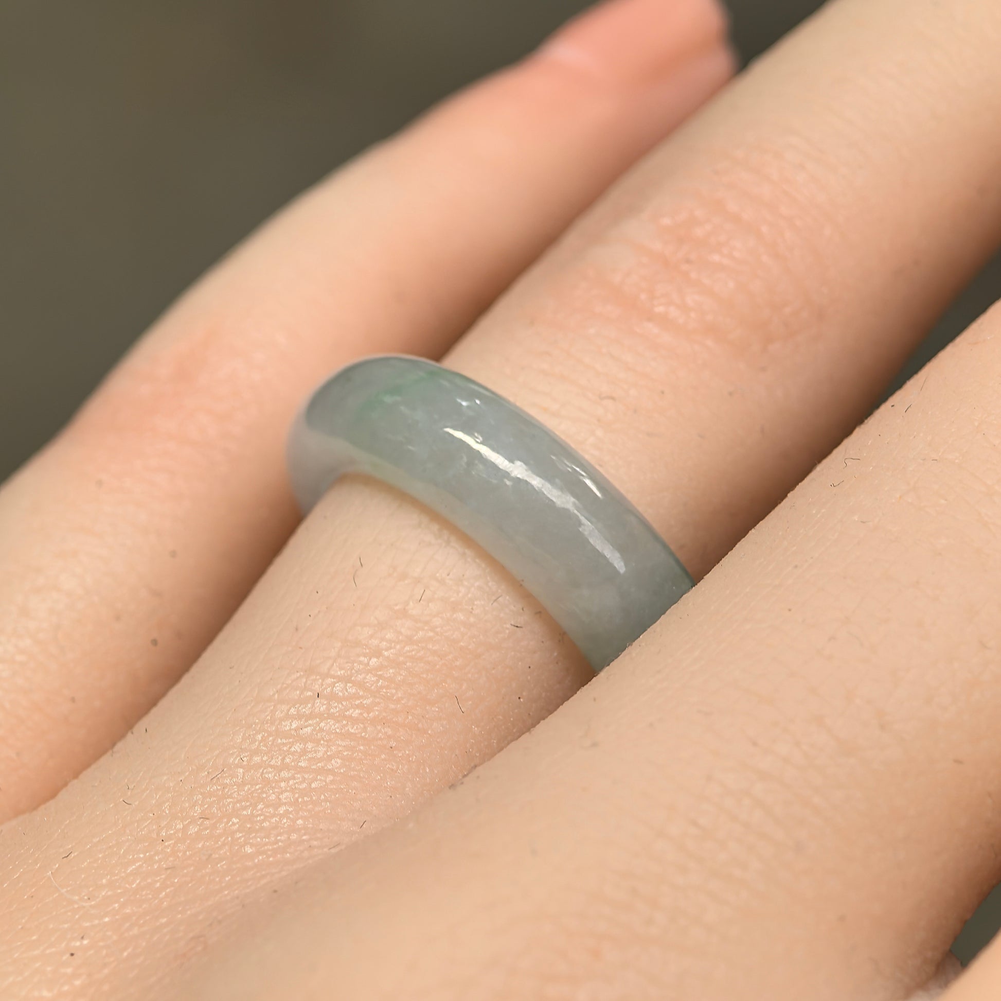 Natural Grade-A icy glutinous light green jadeite ring band worn on a finger, showing its rounded polished profile.